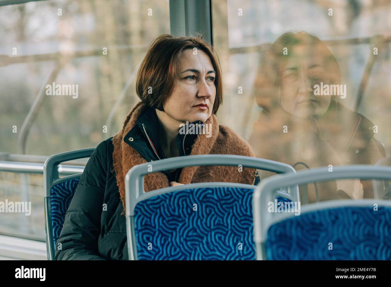 Donna matura e premurosa seduta in tram Foto Stock
