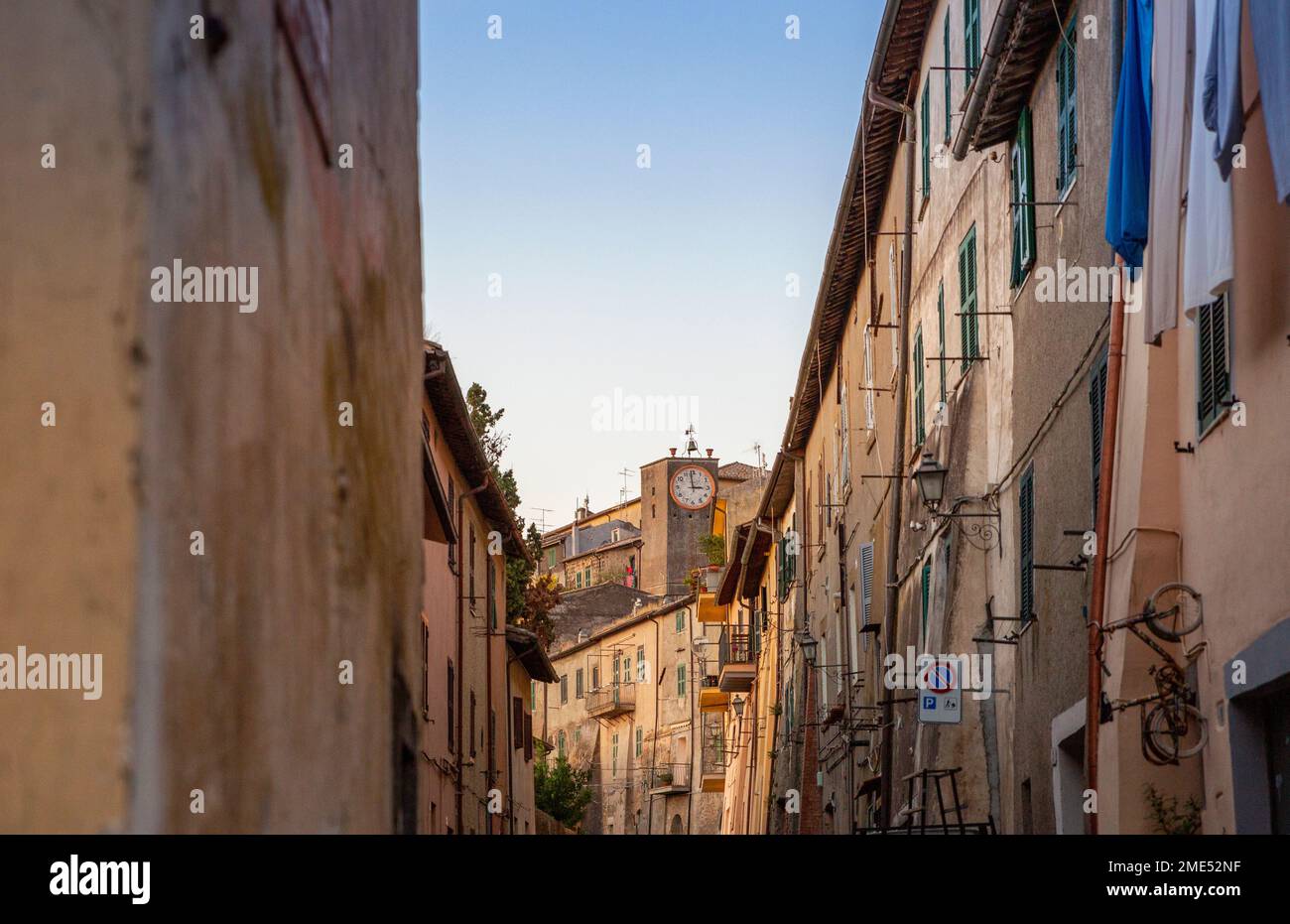 Italia, Lazio, Capodimonte, file di case con orologio pubblico sullo sfondo Foto Stock