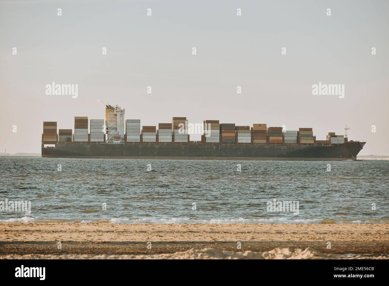 Paesi Bassi, Zeeland, Groede, nave container con spiaggia in primo piano Foto Stock