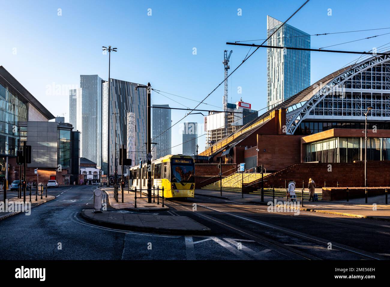 Regno Unito, Inghilterra, Manchester, funivia passando strada con grattacieli del centro in background Foto Stock