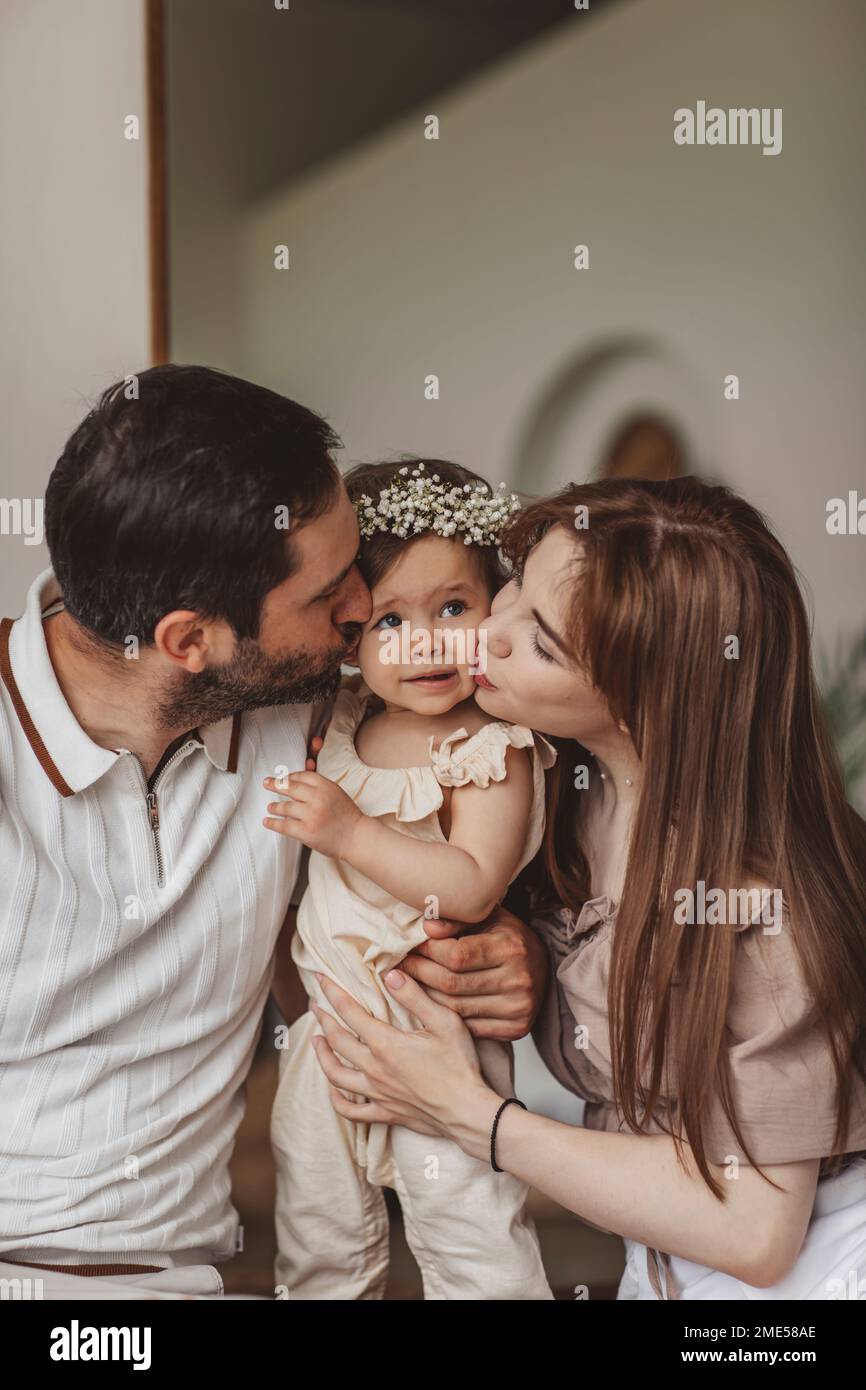 I genitori baciano la figlia a casa Foto Stock