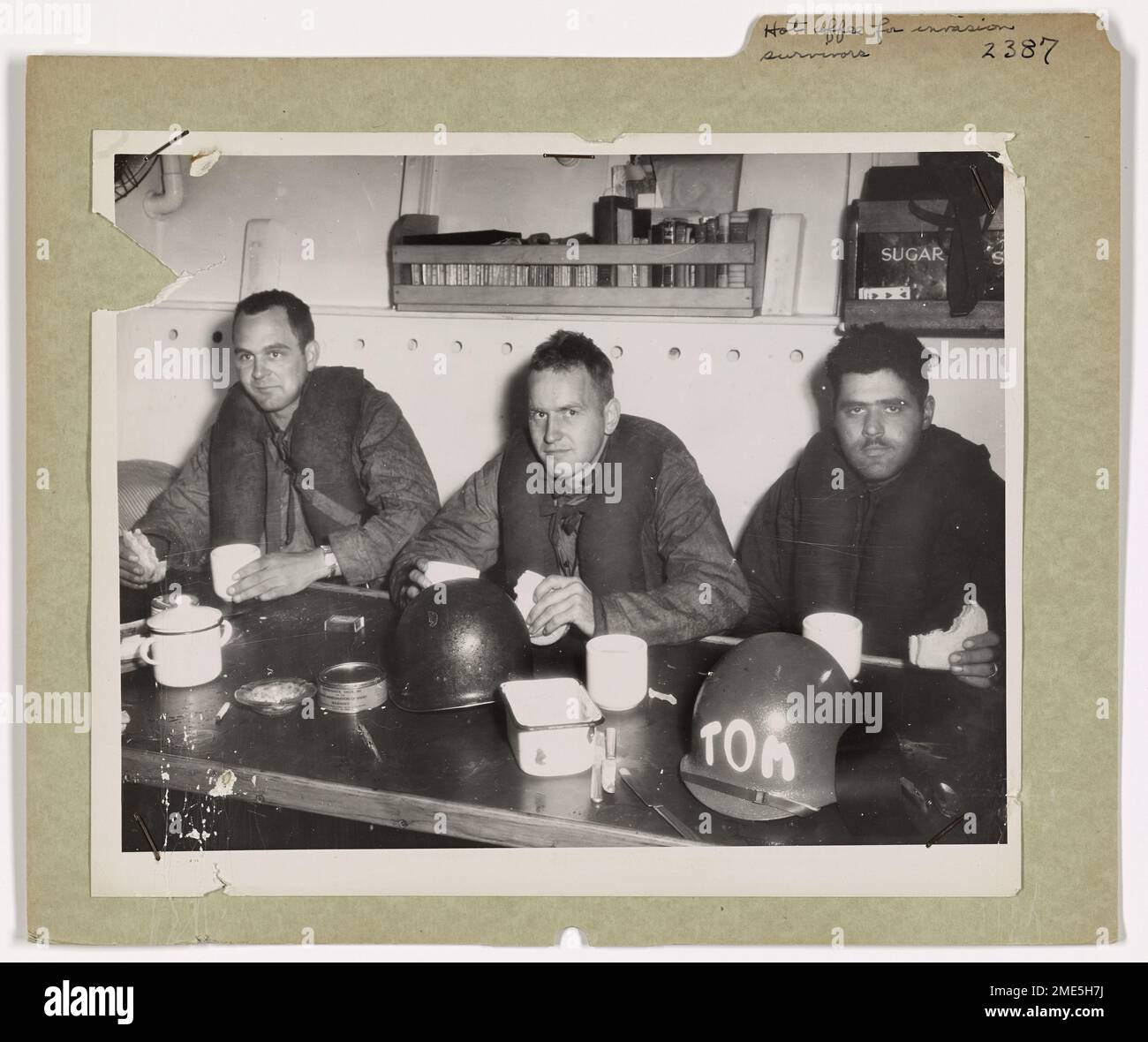 Dopo che i loro mezzi da sbarco affondarono al largo della costa francese, i sopravvissuti dell'esercito bevono caffè caldo e mangiano panini a bordo di un mezzo di salvataggio della Guardia Costiera di 83 piedi. Gli uomini sono stati estratti dalle acque dalla nave di salvataggio, che faceva parte della Guardia Costiera Invasion Rescue Flotilla. Foto Stock