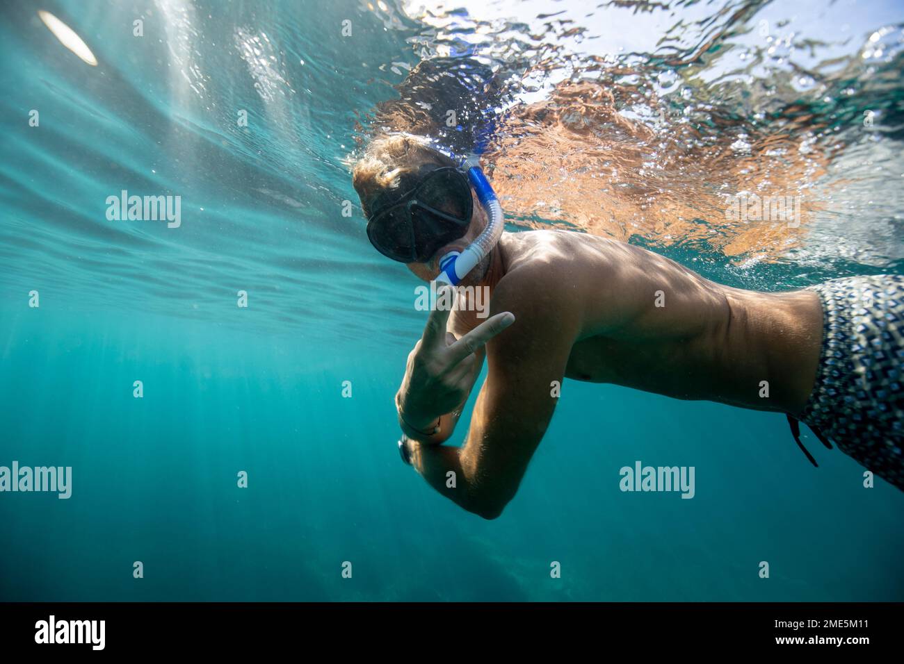 in mare, un uomo in costume da bagno è snorkeling Foto Stock