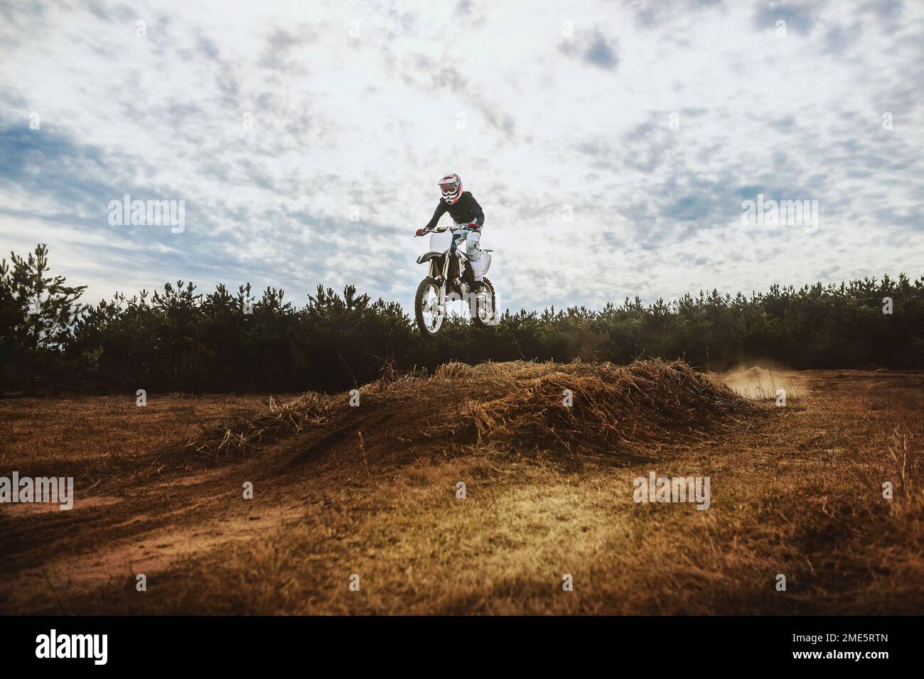 Giovane uomo in bici sterrata salta nel cielo blu Foto Stock