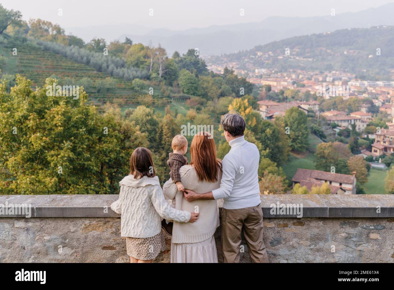 Una giovane famiglia con due figli, una ragazza adolescente e un bambino, si erge con le spalle sullo sfondo delle verdi colline e vigneti di i Foto Stock