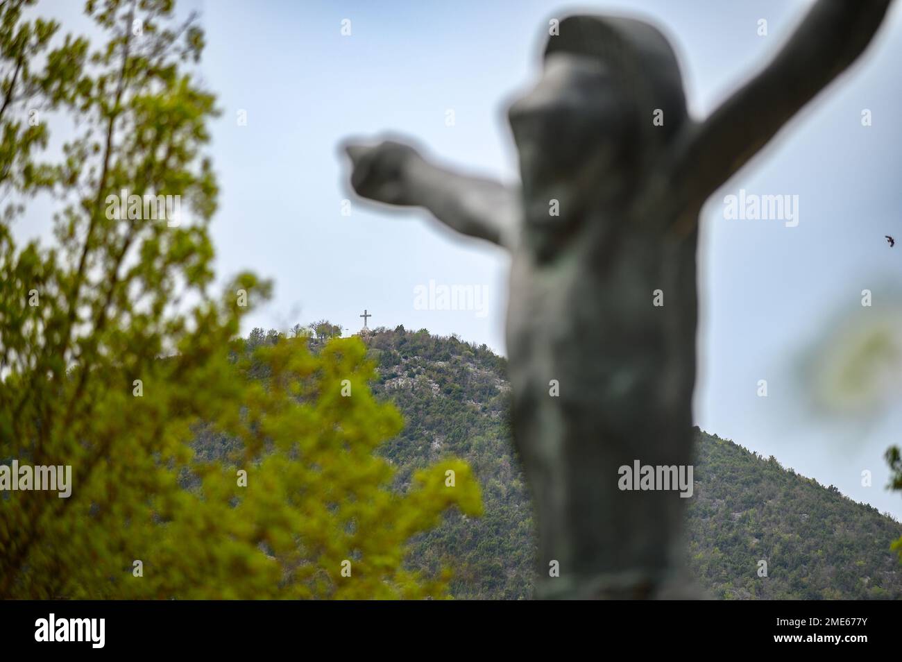 Monte Križevac con la statua del Cristo risorto in primo piano. Medjugorje, Bosnia-Erzegovina. Foto Stock