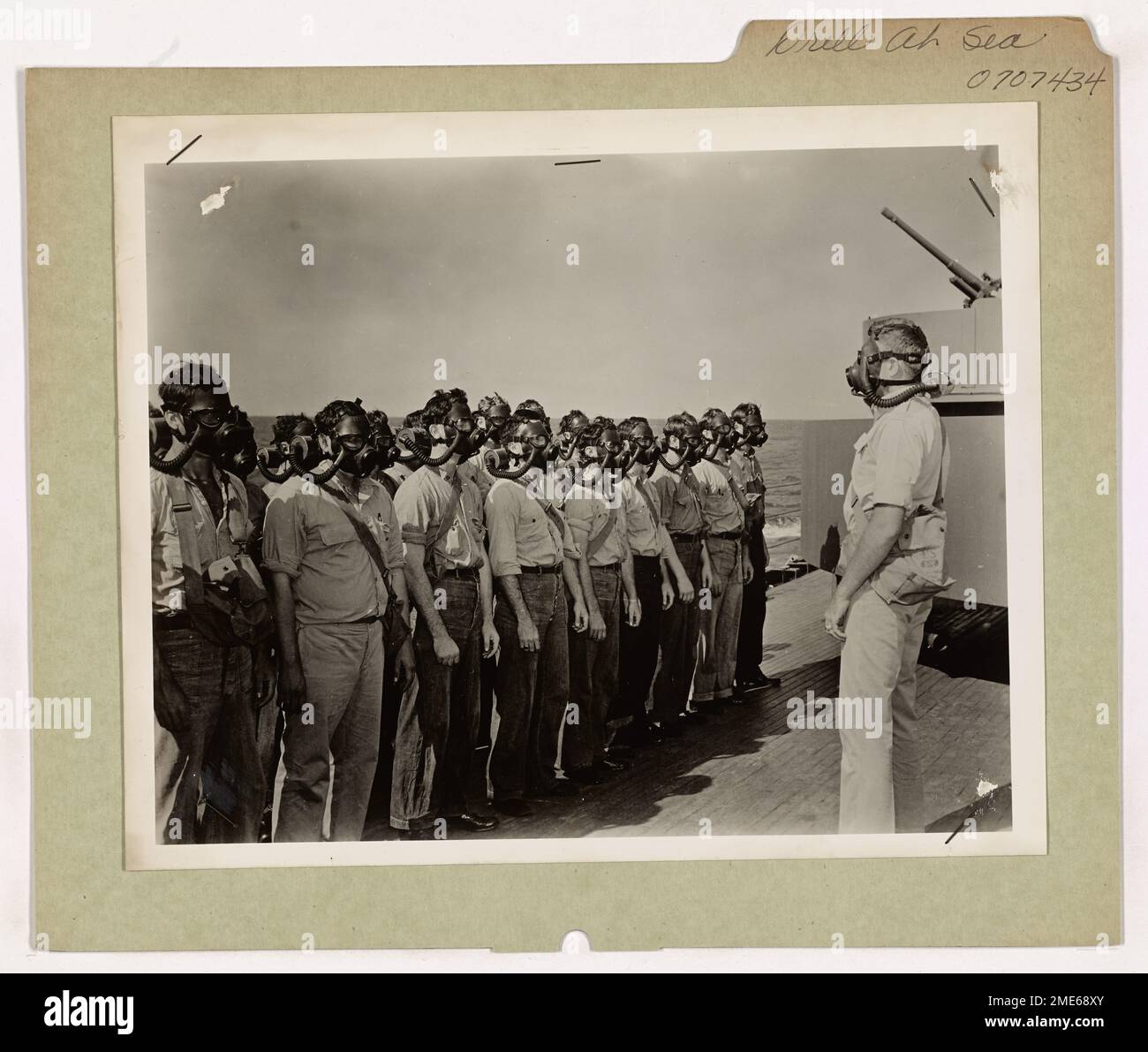 Questa immagine raffigura un cutter da combattimento della Guardia Costiera degli Stati Uniti in mare, dove le guardie costiere vengono perforate nell'uso di maschere antigas come parte del loro addestramento per la difesa da guerra chimica durante le operazioni di guerra. Foto Stock