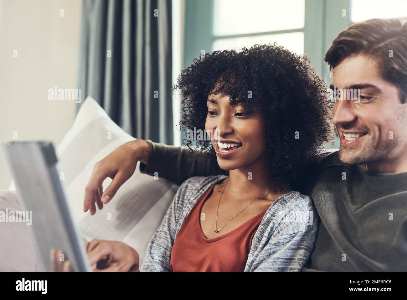 I giorni trascorsi insieme sono sempre speciali. una giovane coppia affettuosa che utilizza un tablet digitale insieme e che trascorre un po' di tempo di qualità insieme a casa Foto Stock