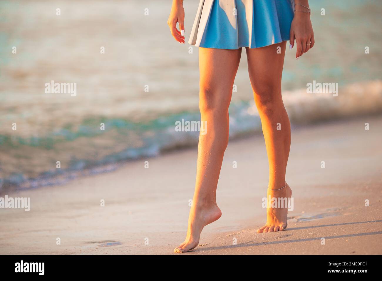 Le gambe della ragazza teen sul primo piano della spiaggia. Ragazza che cammina sulla spiaggia Foto Stock