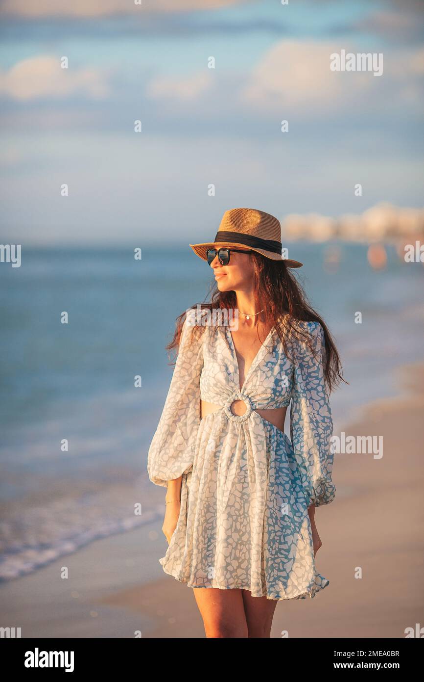 Giovane donna felice sulla spiaggia godere la sua vacanza estiva al tramonto Foto Stock
