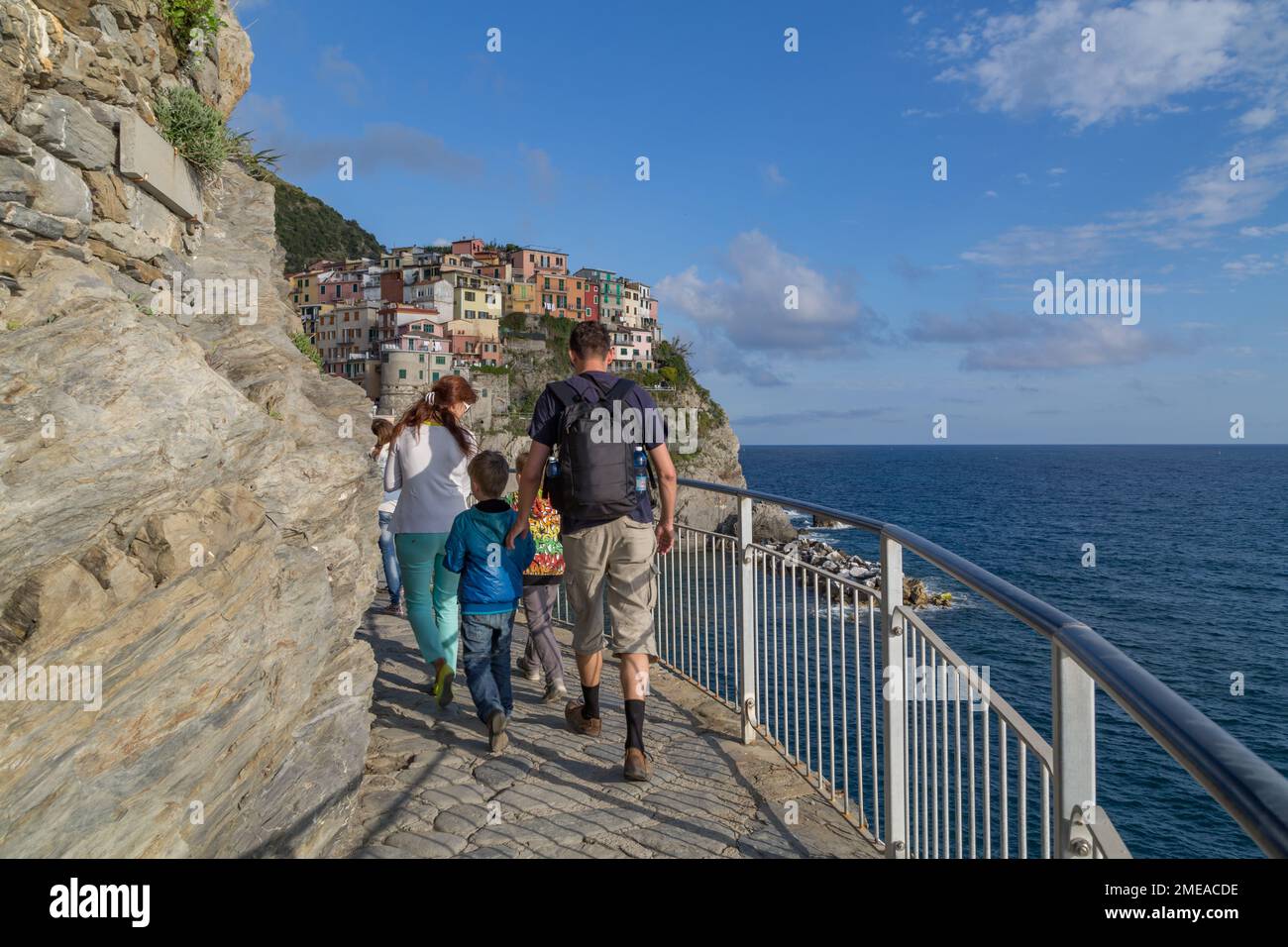 Passeggiata in famiglia lungo il sentiero in pietra che conduce verso il villaggio costiero di Manarola, cinque Terre, Italia. Foto Stock