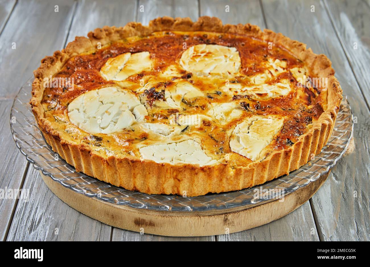 Quiche di formaggio di capra su uno sfondo di legno. Cucina francese gourmet Foto Stock