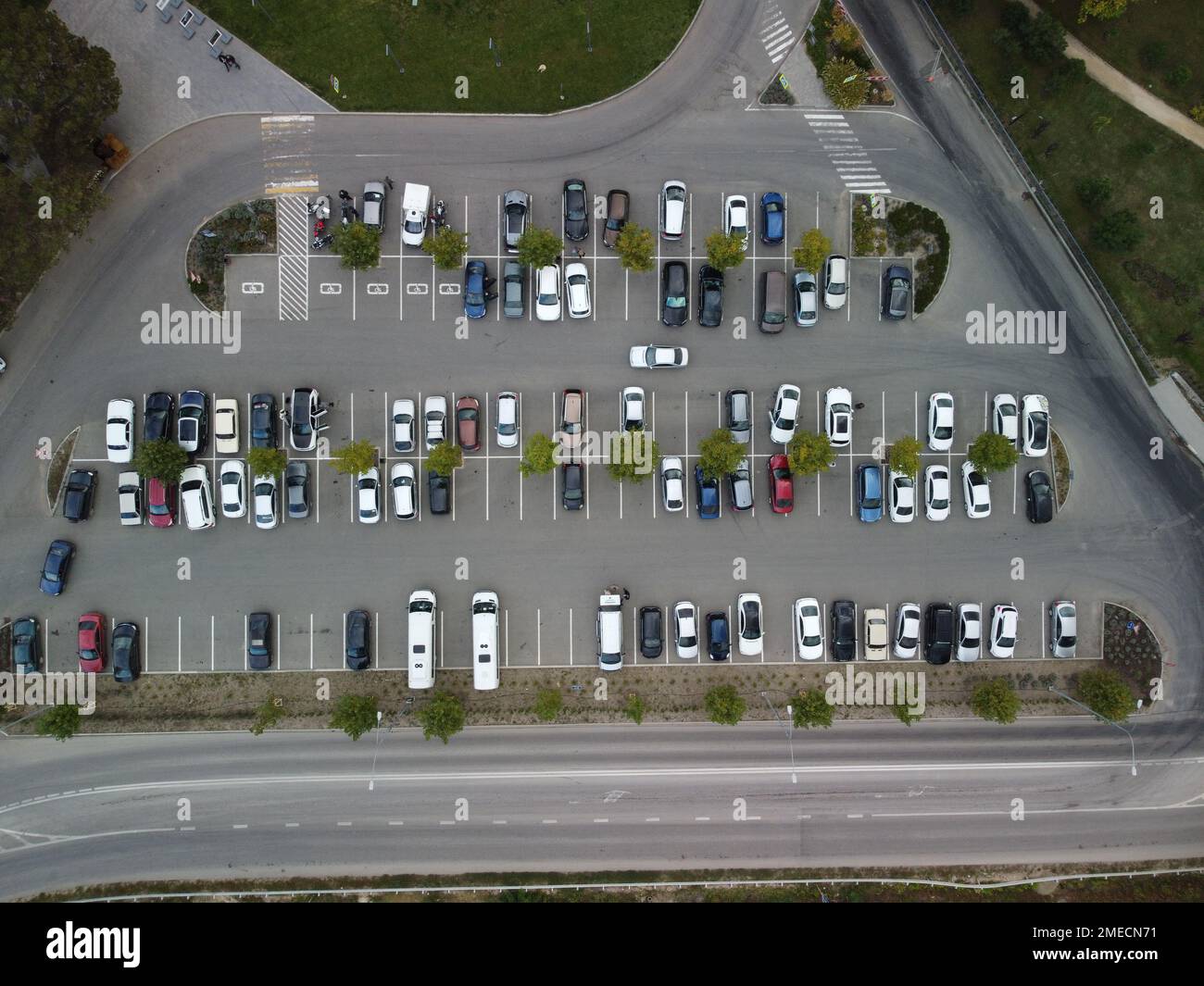 Ampio e affollato parcheggio moderno con strade simmetriche file di piazzole di parcheggio molto simmetriche e colori vista aerea dal drone in alto guardando in basso. Foto Stock