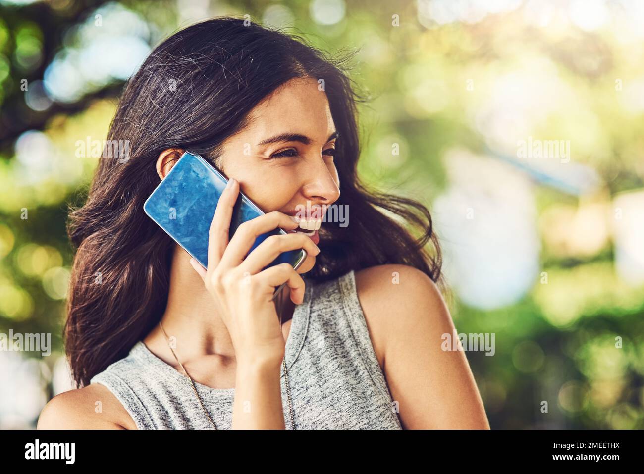 I suoi amici sanno come raggiungerla. una giovane donna attraente che parla su un cellulare all'aperto. Foto Stock