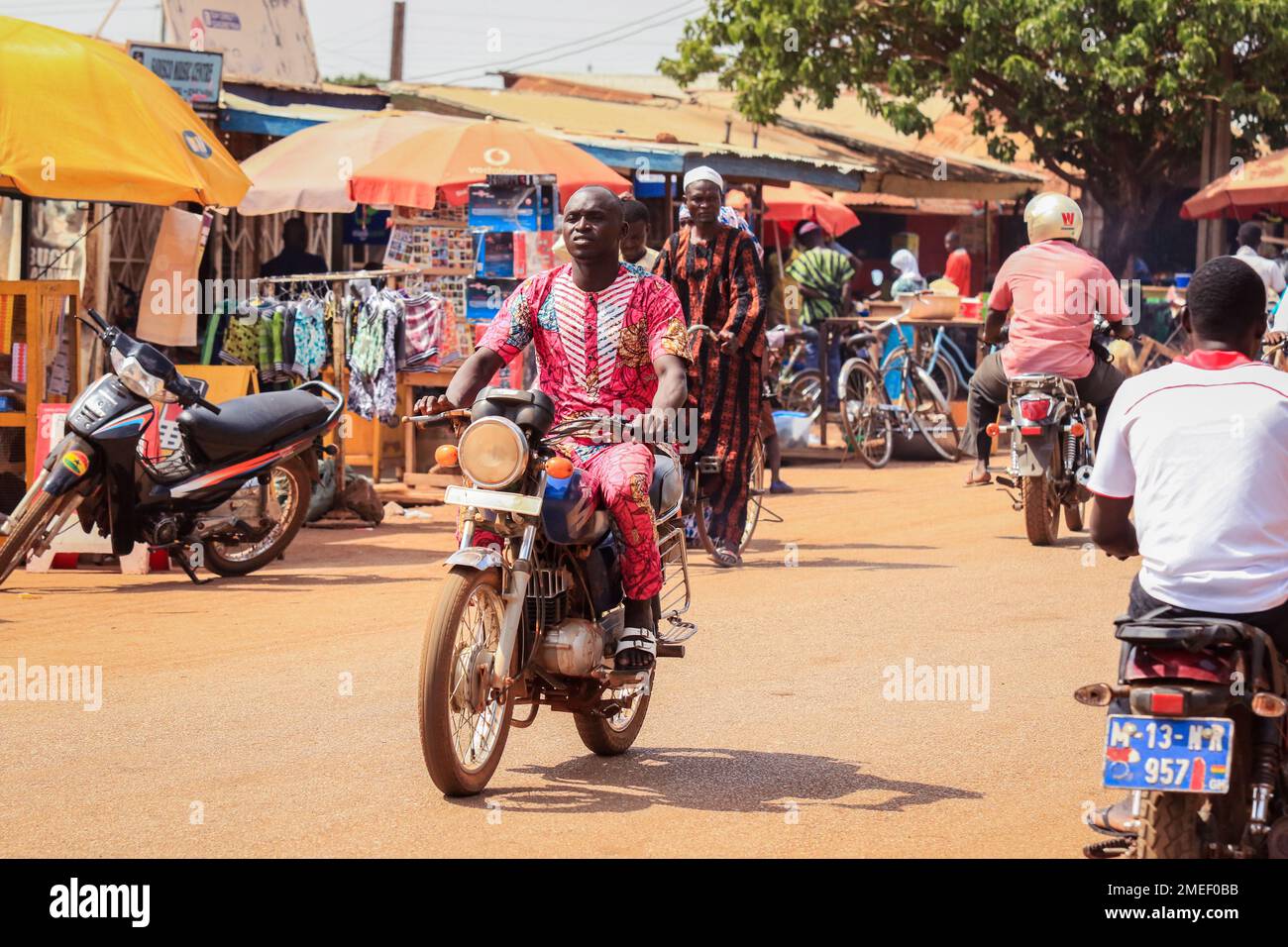 Le persone africane locali che svolgono un lavoro quotidiano nel villaggio del Ghana, Africa occidentale Foto Stock