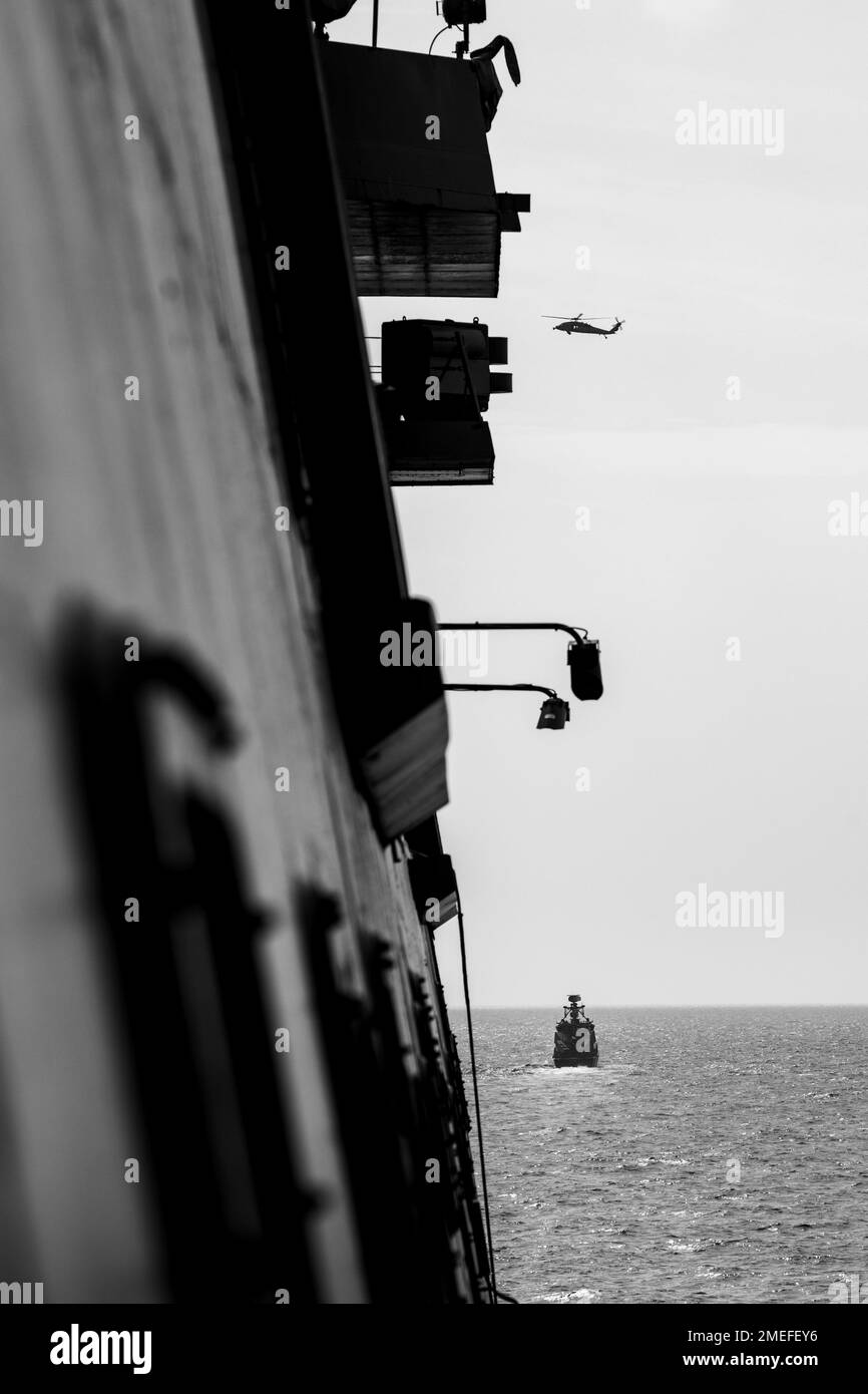 220816-N-PC065-1156 MAR BALTICO (16 agosto 2022) – Un elicottero MH-60s Sea Hawk, schierato a bordo della nave d'assalto anfibio di classe Wasp USS Kearsarge (LHD 3), visto dalla nave portuale anfibia di trasporto di classe San Antonio USS Arlington (LPD 24), in primo piano, sorvola l'imbarcazione di pattuglia di classe Rauma finlandese FGGGSN 72 Porvoo (PSN) Durante un esercizio fotografico nel Mar Baltico, 16 agosto 2022. Il Kearsarge Anfibio Ready Group e la 22nd Marine Expeditionary Unit, sotto il comando e il controllo della Task Force 61/2, sono in programma di schieramento negli Stati Uniti Naval Forces Europe area delle operazioni, impiegare Foto Stock