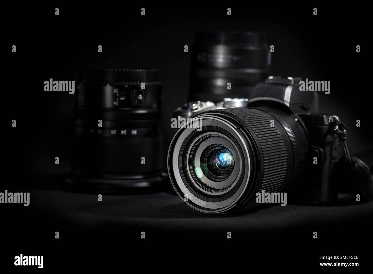 Fotocamera digitale con obiettivi su sfondo nero, attrezzature tecniche per il business, l'arte, il giornalismo o l'hobby, spazio copia, messa a fuoco selezionata, n Foto Stock