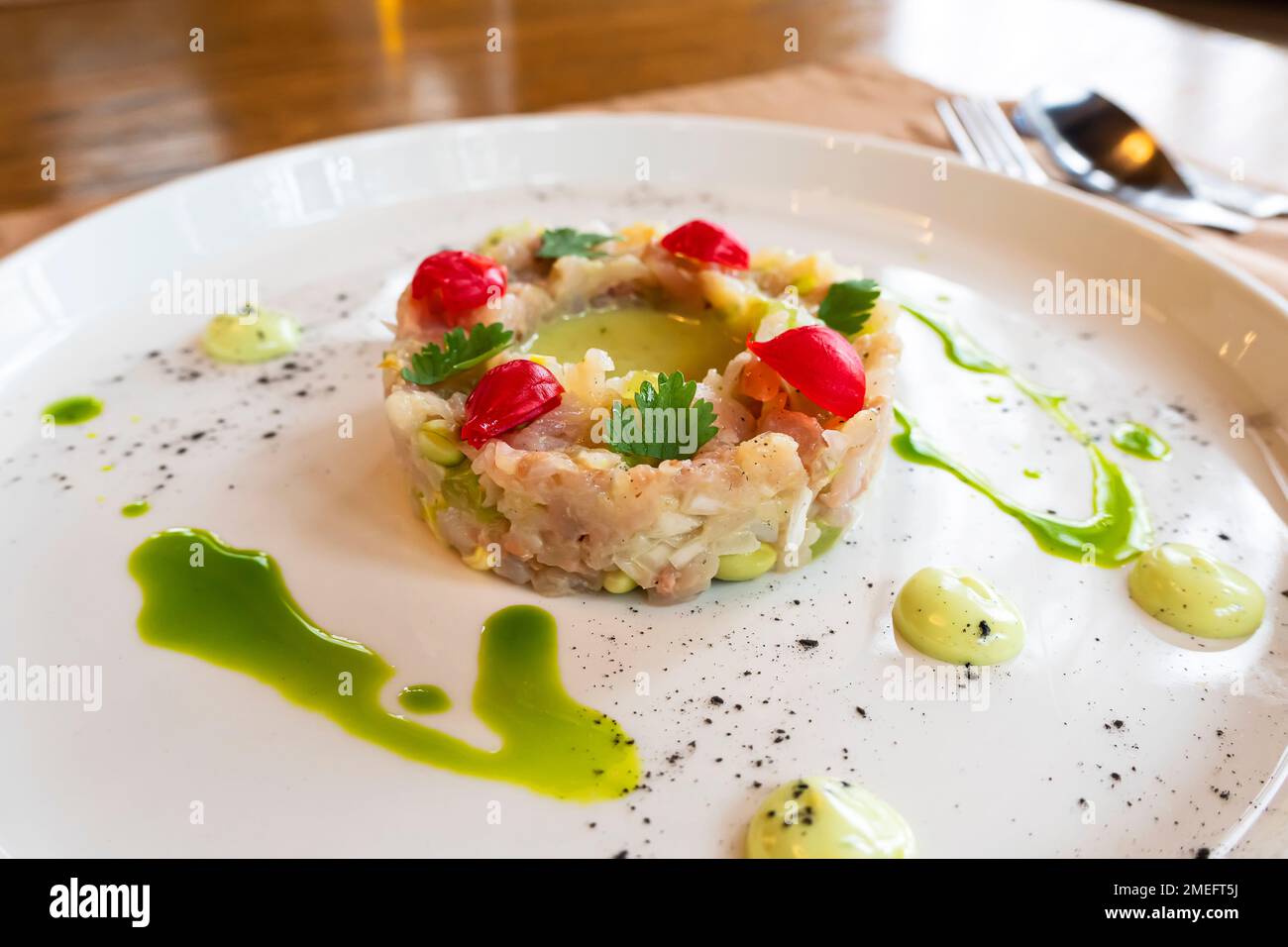 L'insalata di vari ingredienti è ben organizzata a forma di anello su un piatto bianco. Foto Stock