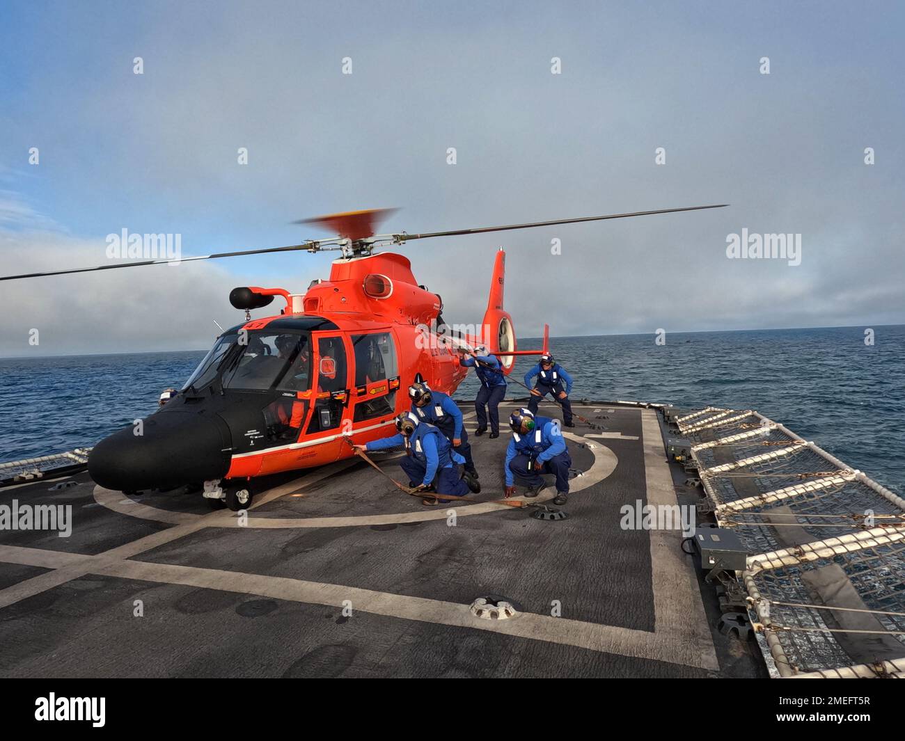 Coast Guard Cutter Coast Guard Cutter Stalfast (WMEC 623) i membri dell'equipaggio del ponte di volo si esercitano a rimuovere i cravatta primari da un elicottero MH-65 Dolphin dalla Air Station Humboldt Bay come parte del loro processo di qualificazione, mentre la costante pattugliò l'Oceano Pacifico, 16 agosto 2022. Il 3 ottobre 2022, dopo una pattuglia contro la narcotica di 55 giorni, Stafast tornò al loro Astoria homeport. Foto della Guardia Costiera degli Stati Uniti. Foto Stock