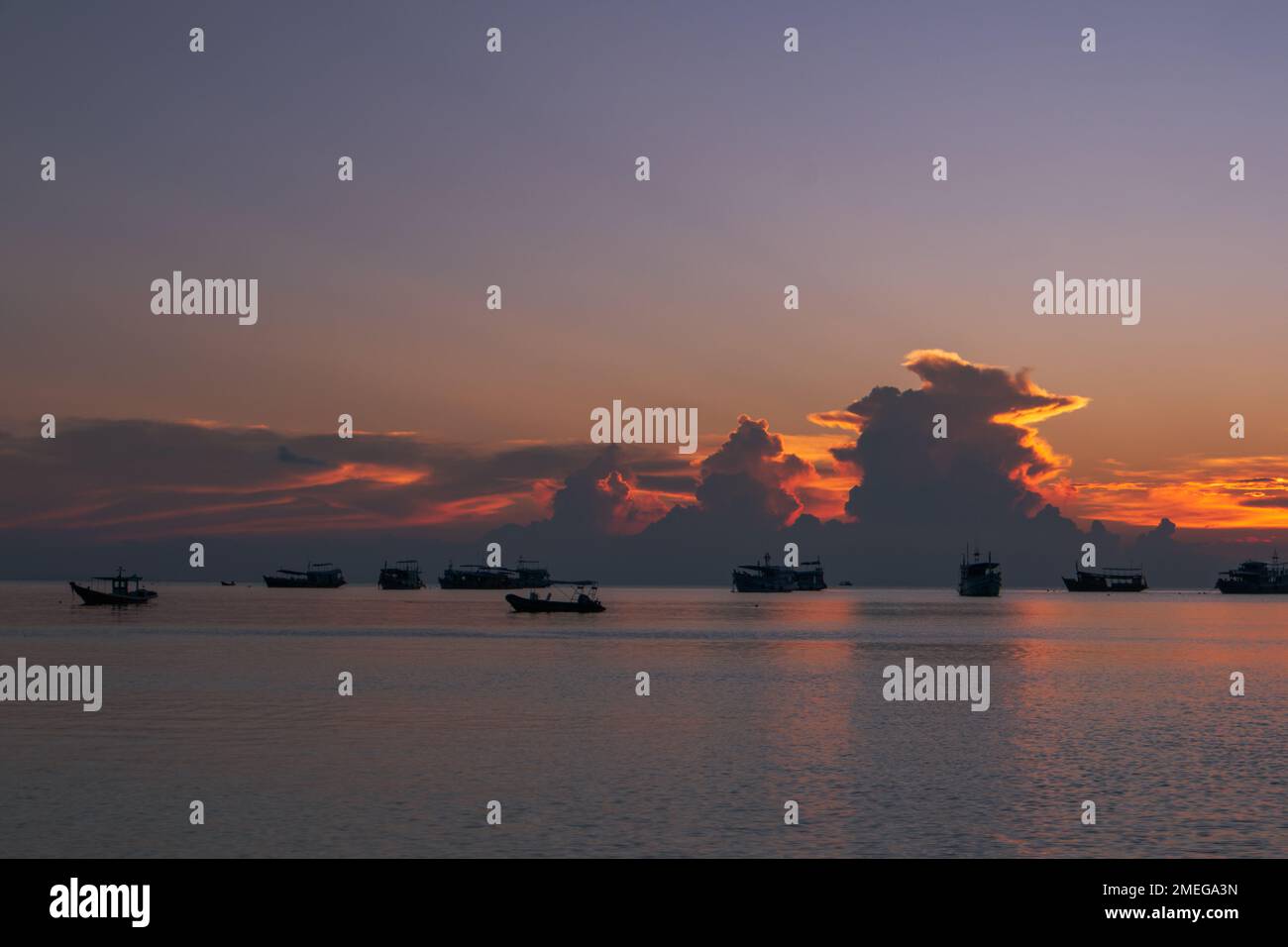 Barche da pesca all'orizzonte di un magnifico tramonto sull'isola di immersioni Koh Tao, Thailandia Foto Stock