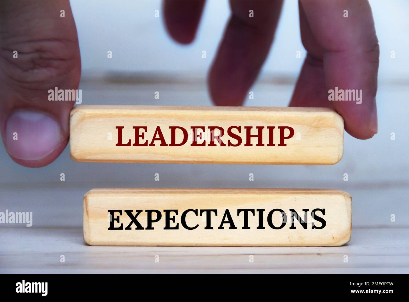 Testo delle aspettative di leadership in mano sui blocchi di legno. Concetto di aspettativa di leadership. Foto Stock