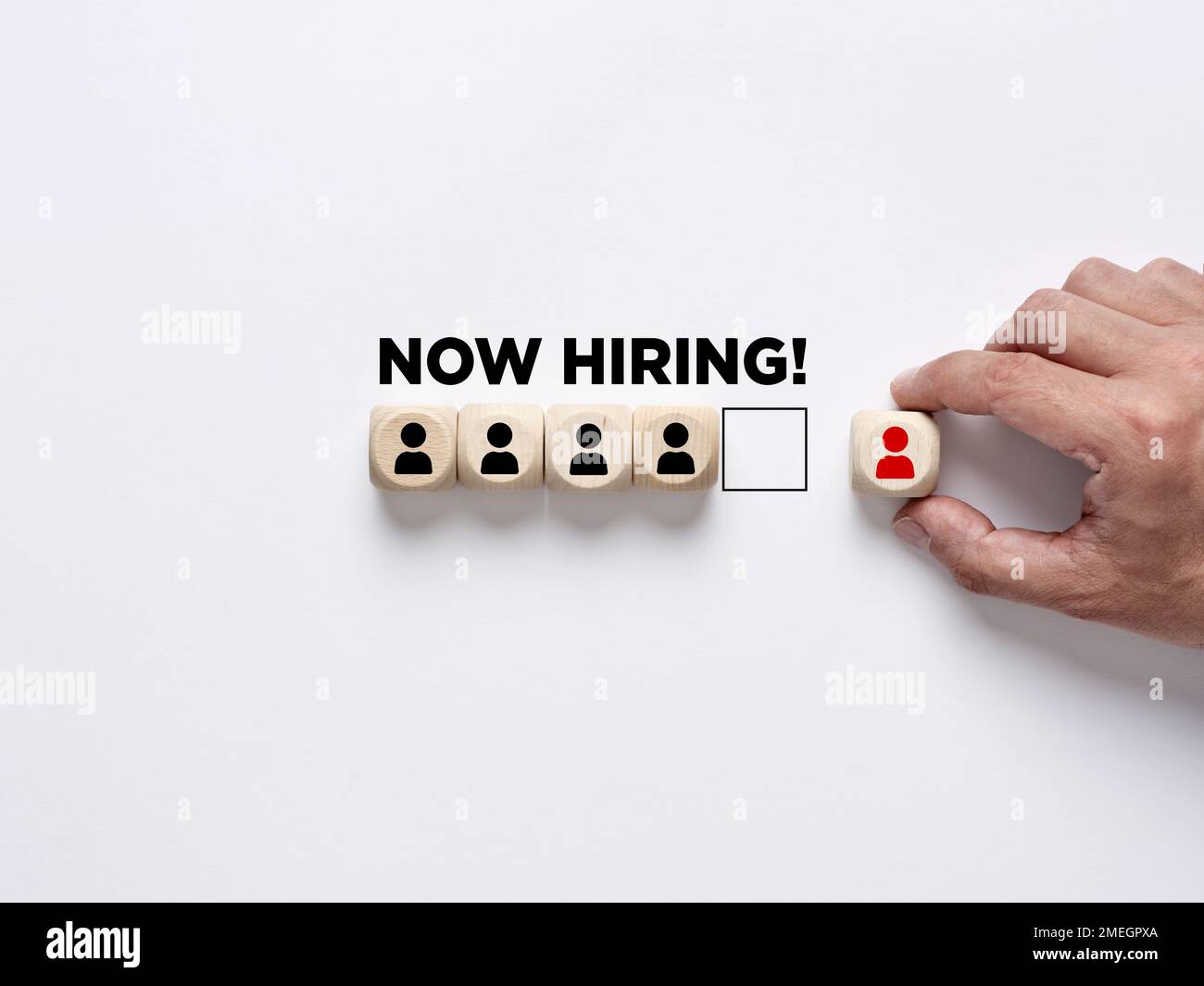 Occupazione, assunzione e concetto di business. Aggiunta di un nuovo giocatore alla squadra. La mano maschile dispone i blocchi di legno con i simboli dei dipendenti con i mes Foto Stock