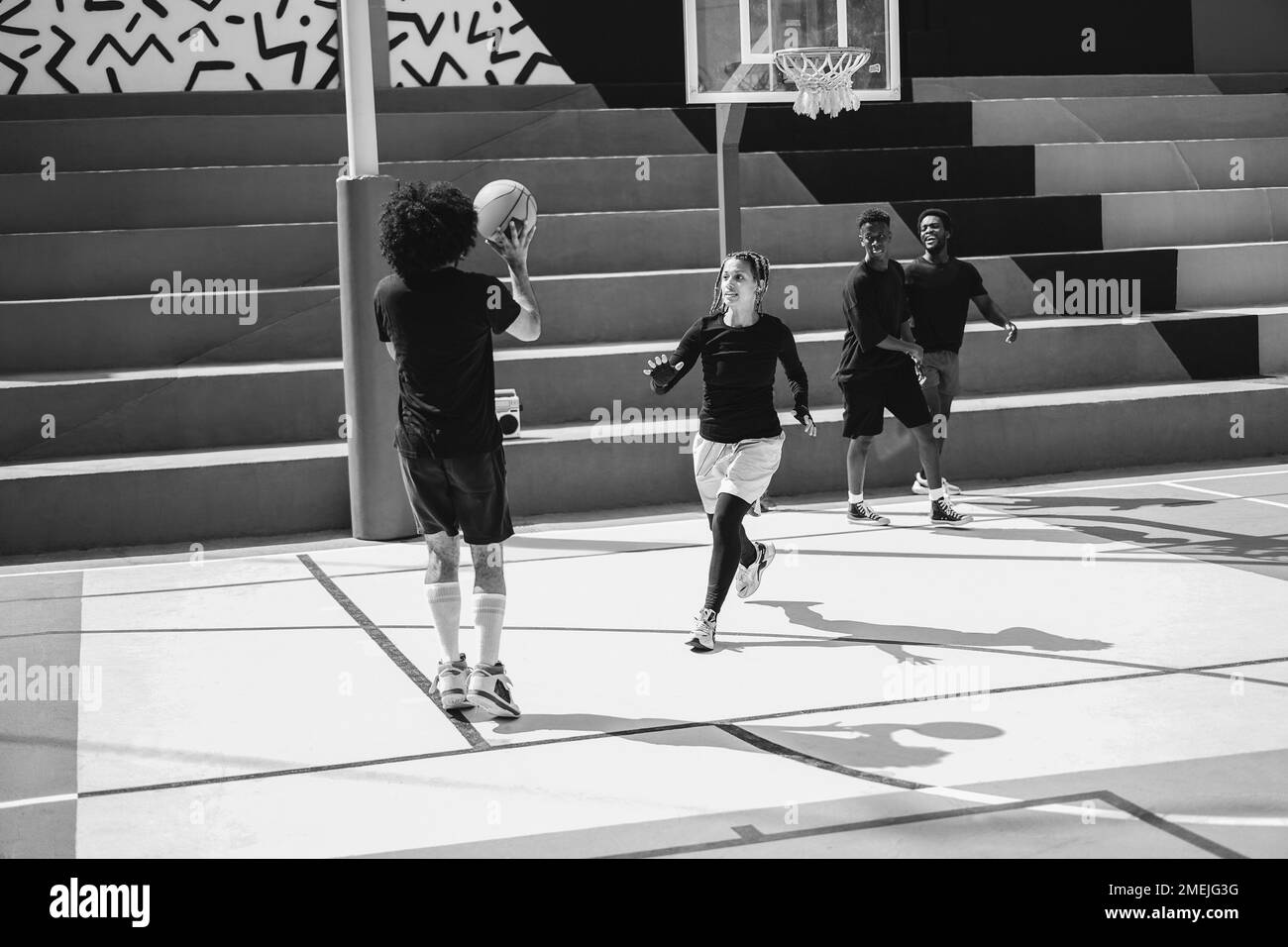 Amici africani che giocano a basket all'aperto - Focus on girl face - editing in bianco e nero Foto Stock