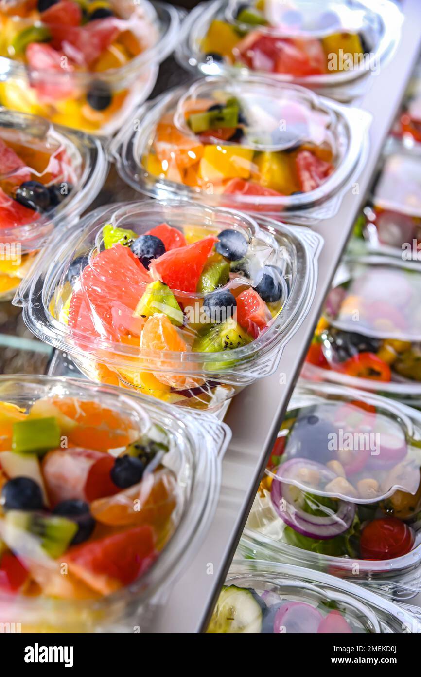 Scatole di plastica con macedonie di frutta preconfezionate, messe in vendita in un frigorifero commerciale Foto Stock