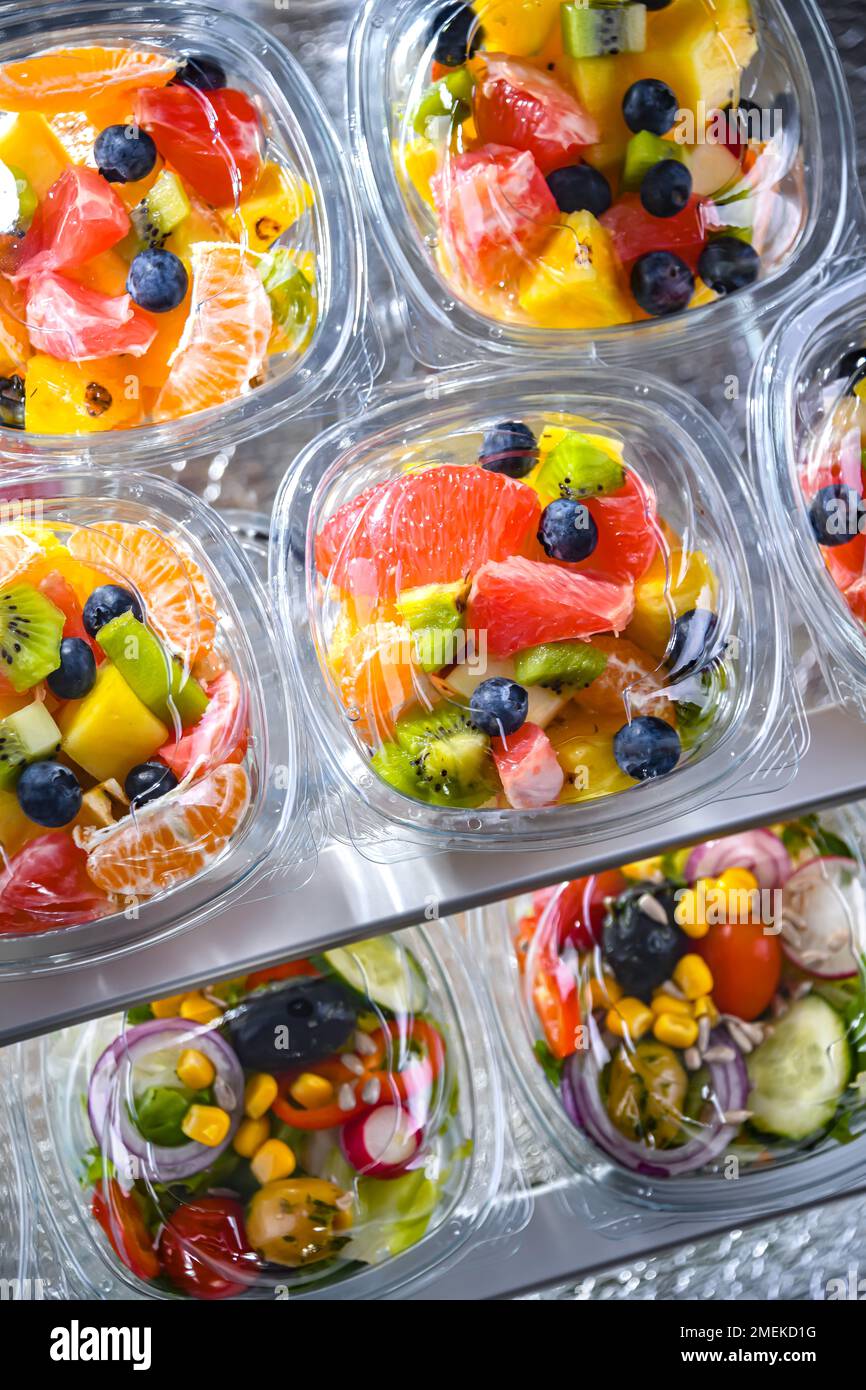 Scatole di plastica con macedonie di frutta preconfezionate, messe in vendita in un frigorifero commerciale Foto Stock