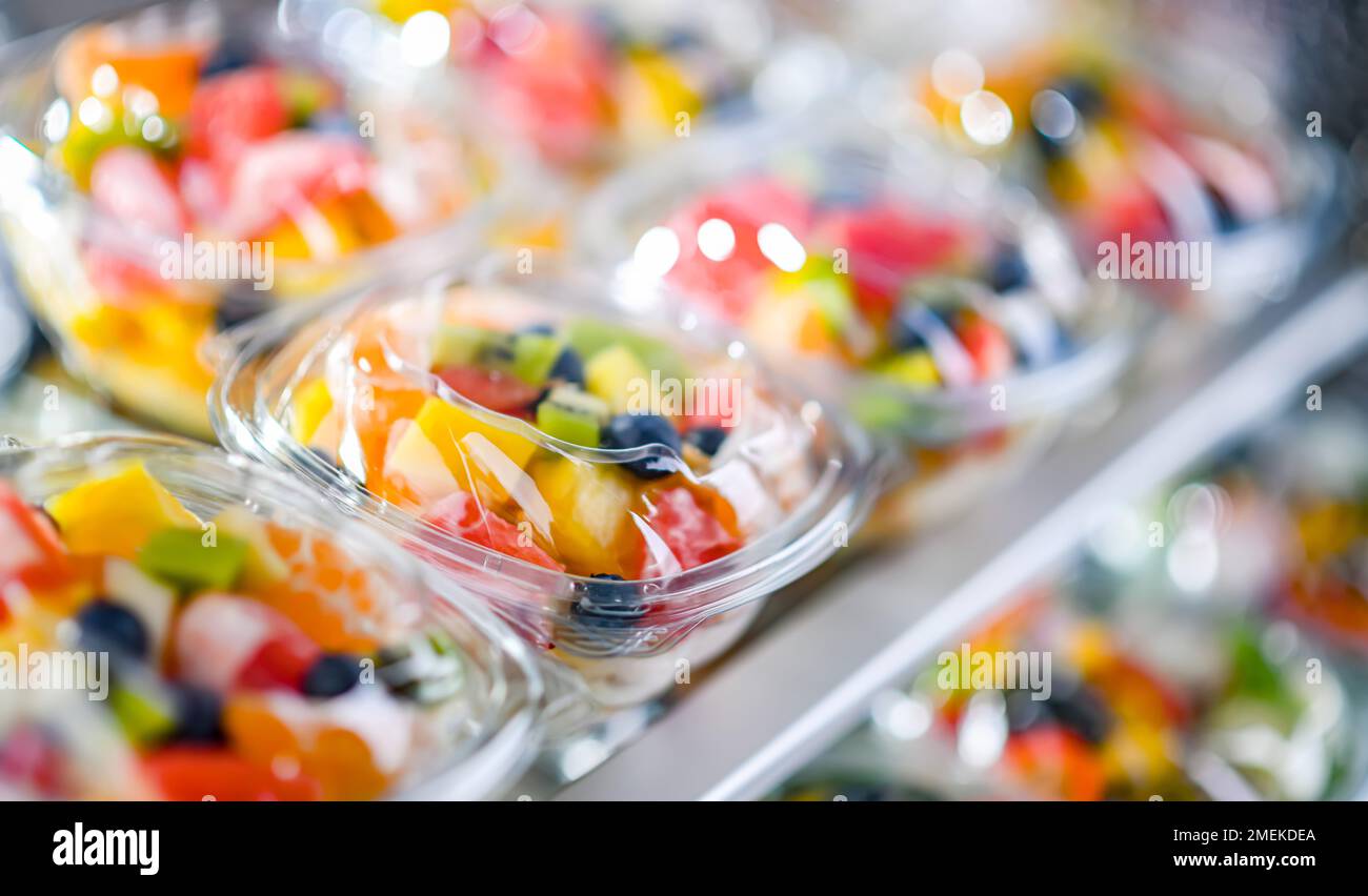 Scatole di plastica con macedonie di frutta preconfezionate, messe in vendita in un frigorifero commerciale Foto Stock
