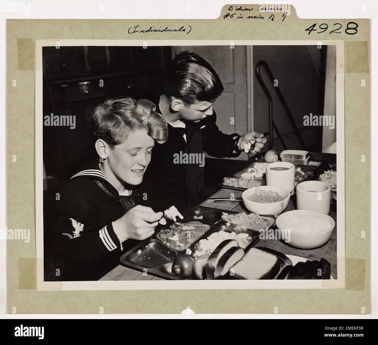 Il ragazzo di mistero del fronte d'acqua tedesco (No. 5 in Una serie di 7 foto). Chow Down - Un uomo di servizio è un mangiatore sostanzioso, per i motivi migliori. Durante il giorno si è fatto un appetito. Dopo una dura giornata di lavoro a bordo della taglierina della Guardia Costiera EAGLE, Eddie sa cosa fare con il chow serale. Può ricordare i giorni in cui i tedeschi superavano la Francia e i mesi dei suoi viaggi e delle sue razioni di scarti. Foto Stock