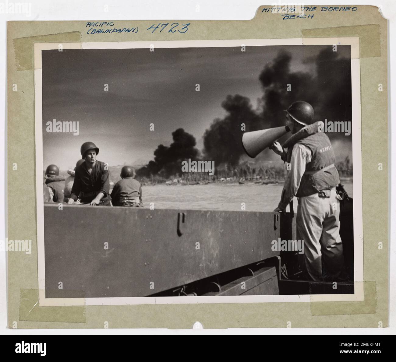 Guardia costiera Lieut. (JG) Clarence W. Loma dirige una barca d'assalto che trasporta truppe australiane a terra durante l'invasione Balikpapan nel Borneo. Gli LST della Guardia Costiera erano parte integrante dell'operazione del D-Day, trasportando sia personale che attrezzature pesanti per proteggere la regione ricca di petrolio dopo l'assalto. Foto Stock