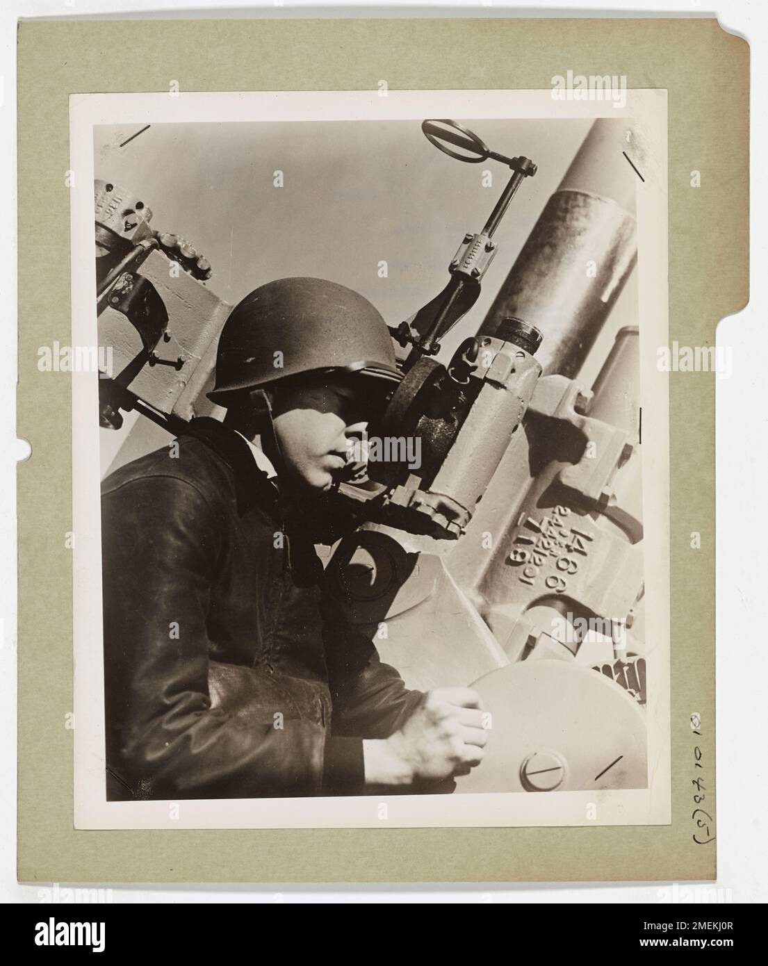Un guardiano costiero, che indossa un casco, si vede regolare la portata di un cannone antiaereo in una base costiera della Guardia Costiera degli Stati Uniti, parte della loro disponibilità durante le operazioni di guerra. Foto Stock