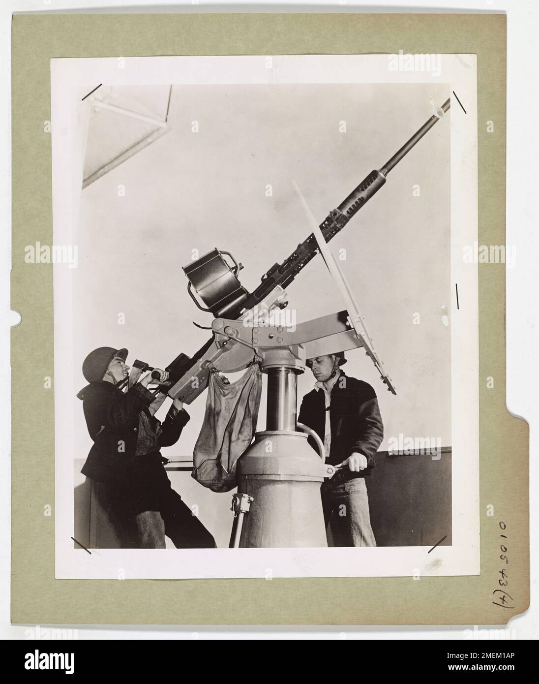 Questa immagine cattura un equipaggio di taglierini della Guardia Costiera che si prepara per un attacco aereo nemico durante un'esercitazione antiaerea. L'equipaggio delle armi dimostra prontezza e vigilanza di fronte a potenziali minacce aviotrasportate. Foto Stock