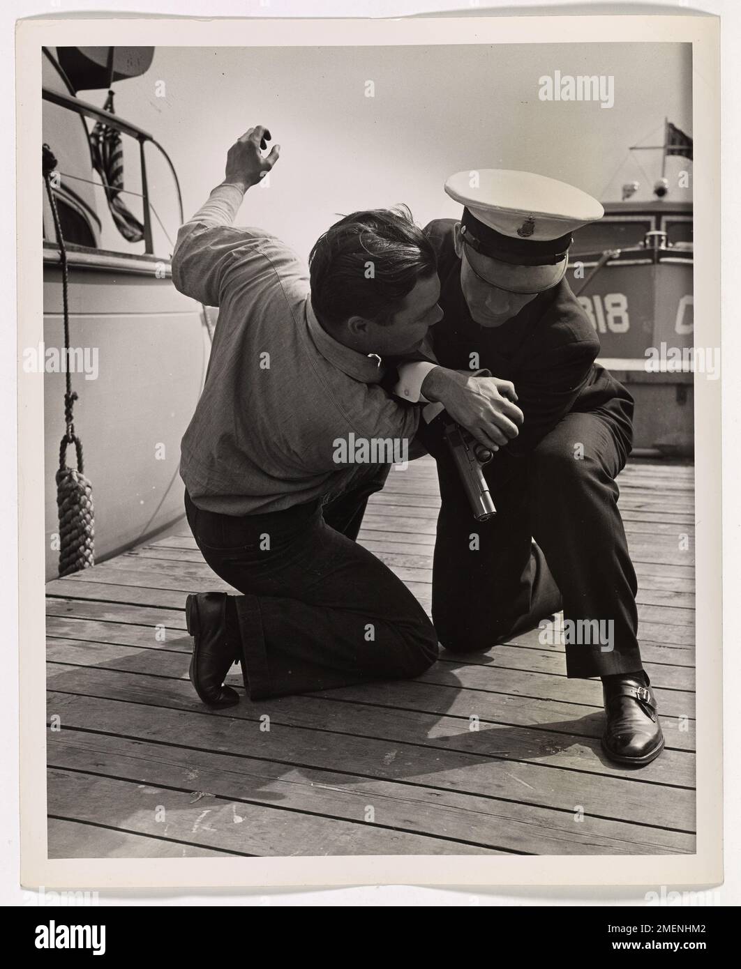 Rollston, un membro della Guardia Costiera, lotta per riguadagnare il suo equilibrio, ma cade durante un esercizio di allenamento. L'immagine cattura un momento chiave nel rigoroso addestramento che gli uomini della Guardia Costiera subiscono per prepararsi alle operazioni di combattimento. Foto Stock