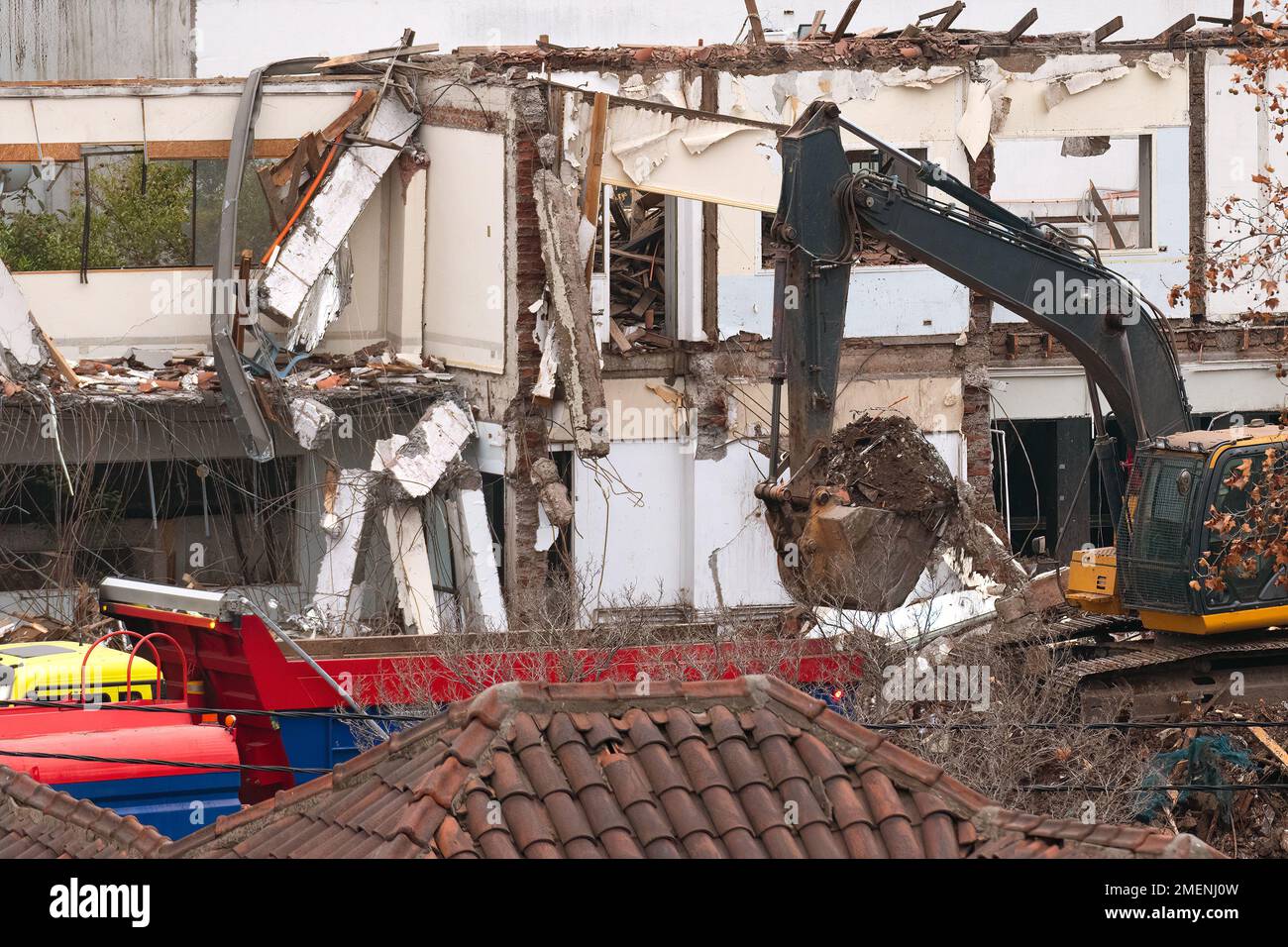 Demolizione di una vecchia casa con un escavatore. Foto Stock