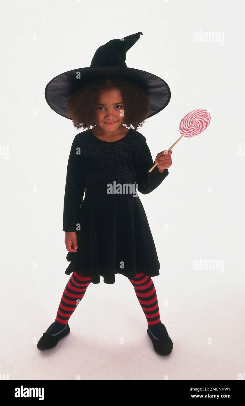 Una ragazza vestita come una strega con tights stripy sopra. Foto Stock