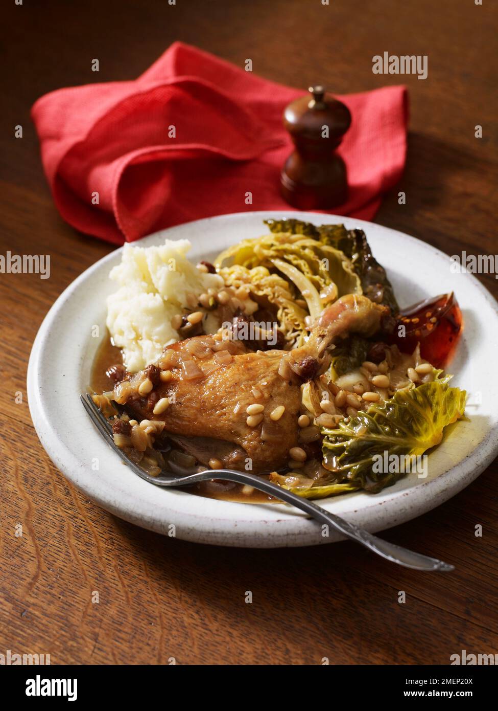 Cosce d'anatra con cavolo, pinoli, uva passa e purea Foto Stock