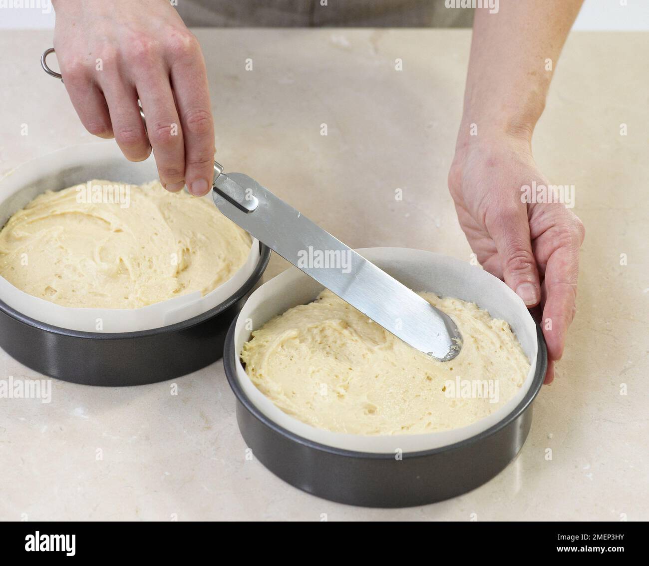 Dividere la miscela di torta di spugna Victoria in barattoli Foto Stock