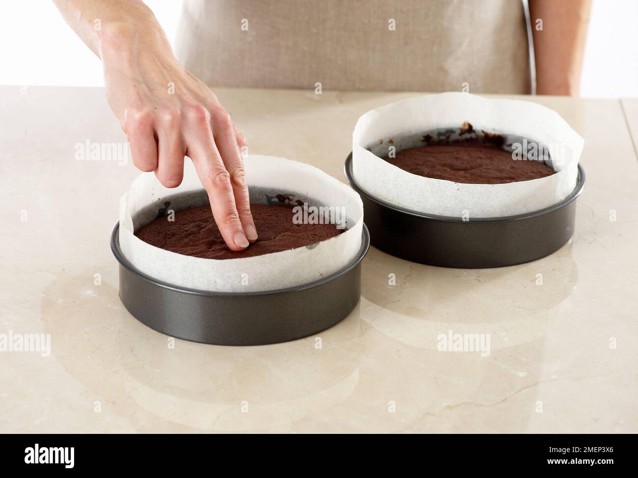 Torta al cioccolato, controllare torta al cioccolato al forno, dovrebbe essere springy al tatto Foto Stock