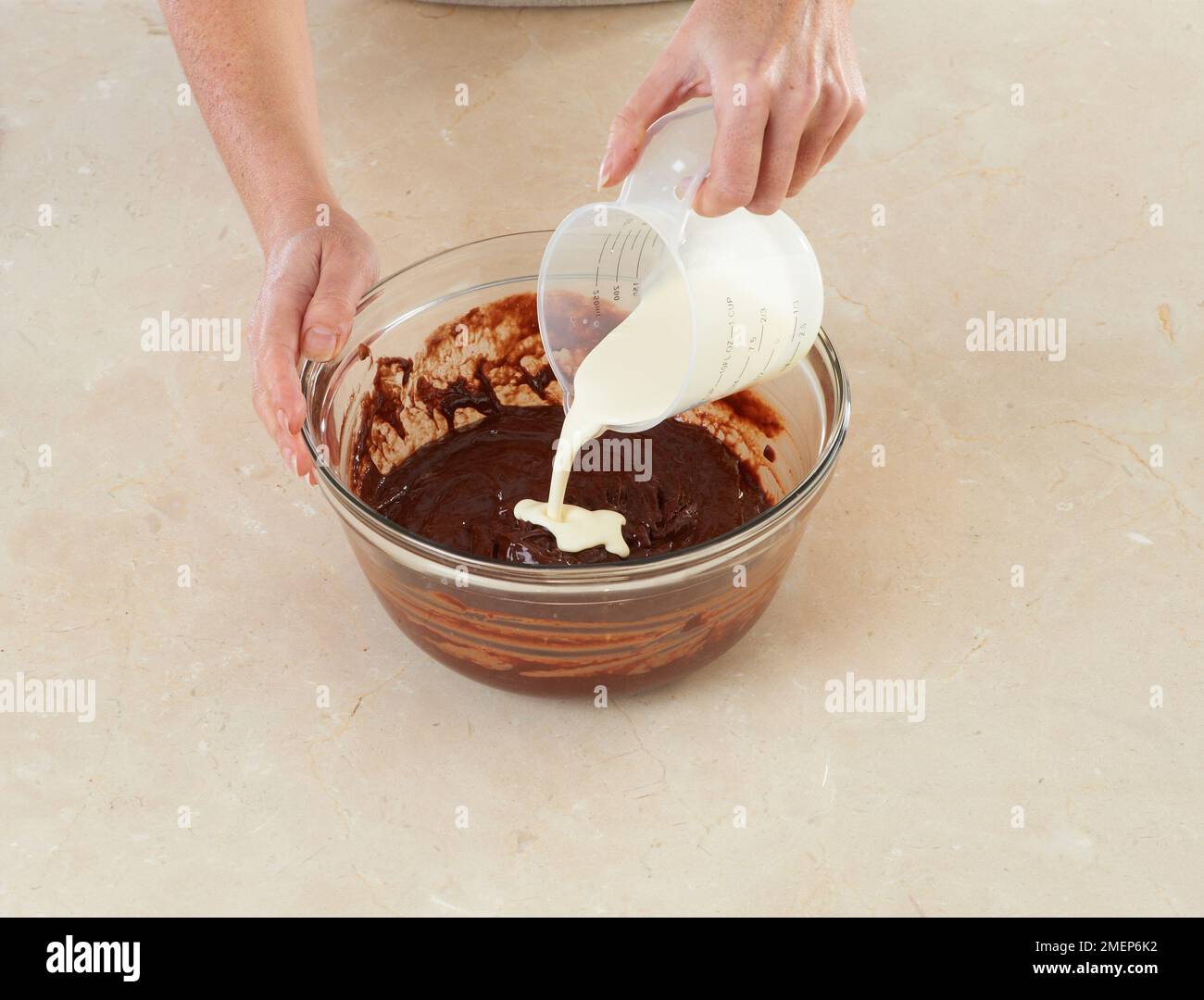 Torta al cioccolato, versando la doppia crema nel composto di cioccolato Foto Stock