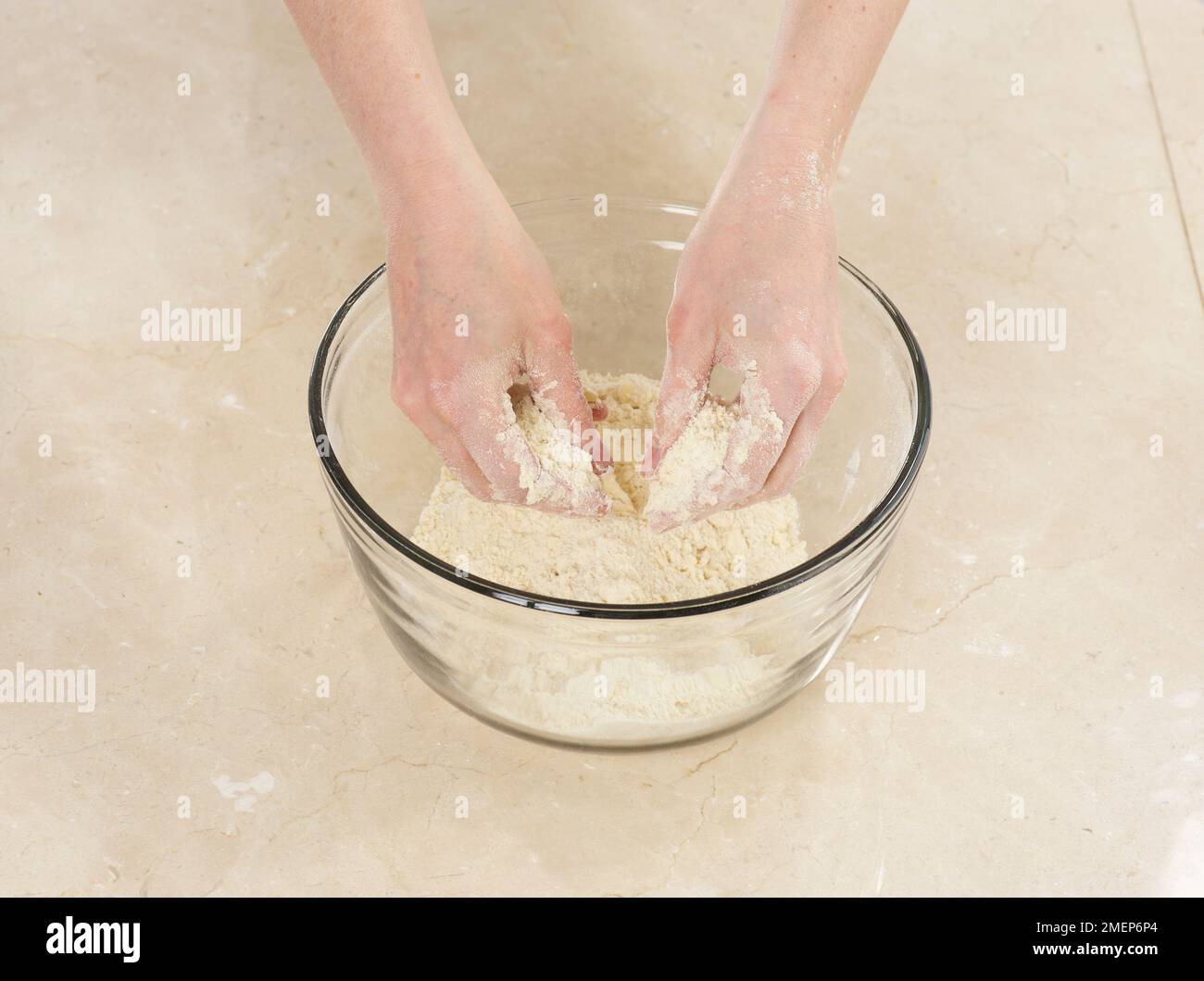 Preparare la pasta di ciottoli, aggiungere il burro e mescolare con le dita fino a quando il composto non assomiglia al pangrattato Foto Stock