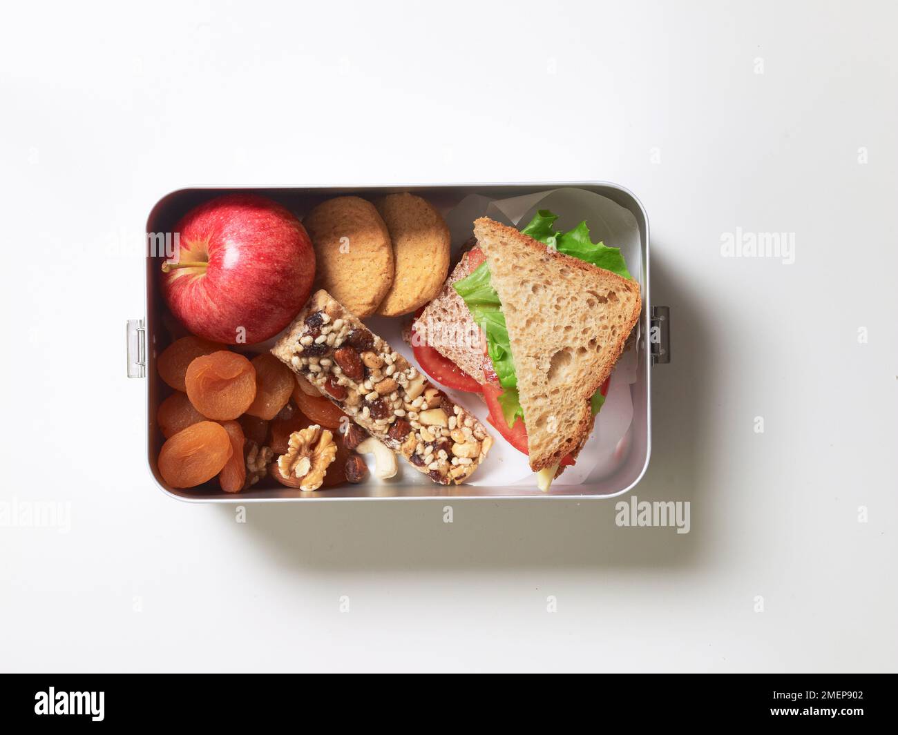 Pranzo al sacco senza glutine con sandwich di lattuga e pomodoro, frutta e noci, biscotti e mela fresca, vista dall'alto Foto Stock