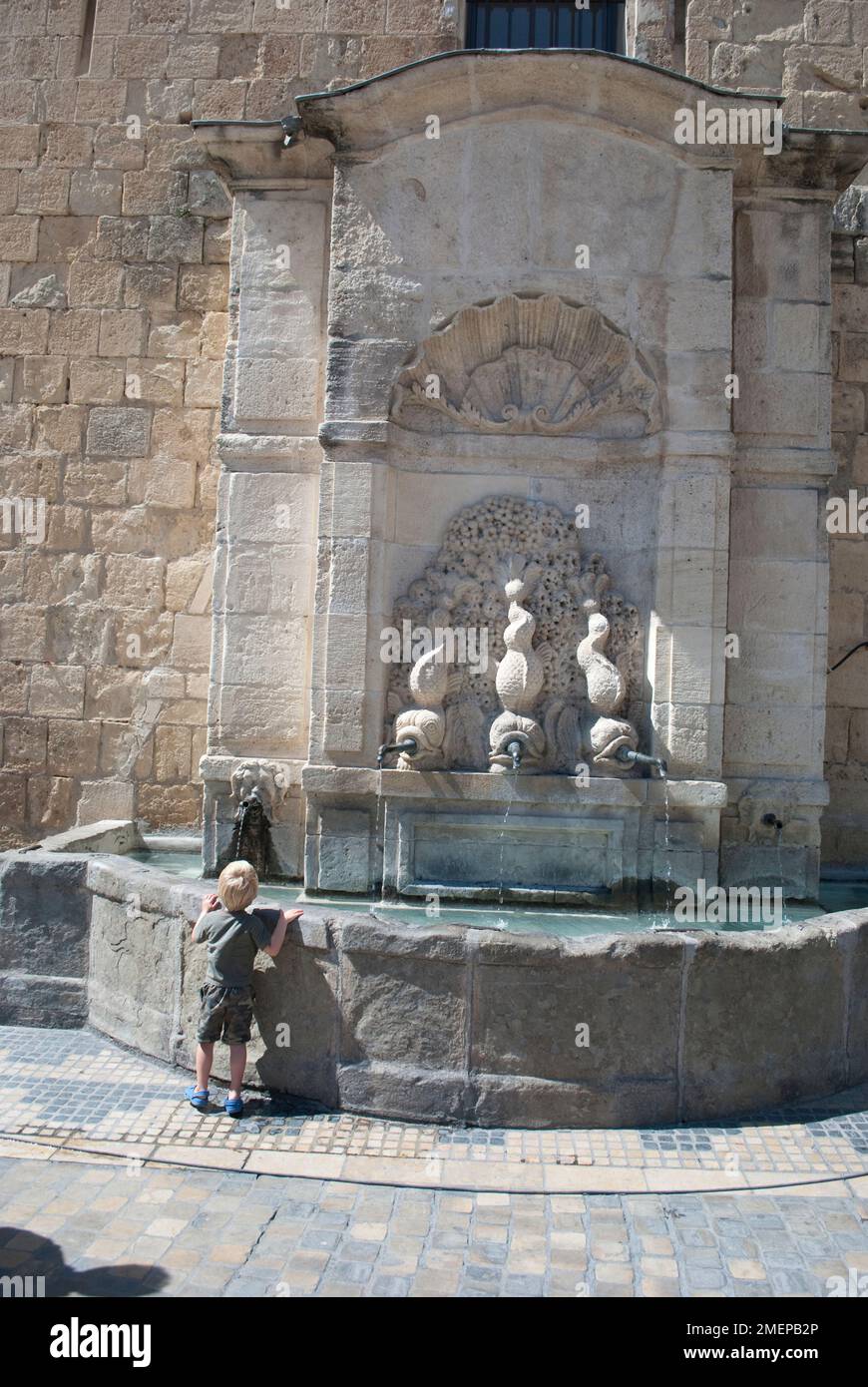 Francia, Languedoc-Roussillon, Aude, Narbonne, Cattedrale, ragazzino alla fontana Foto Stock
