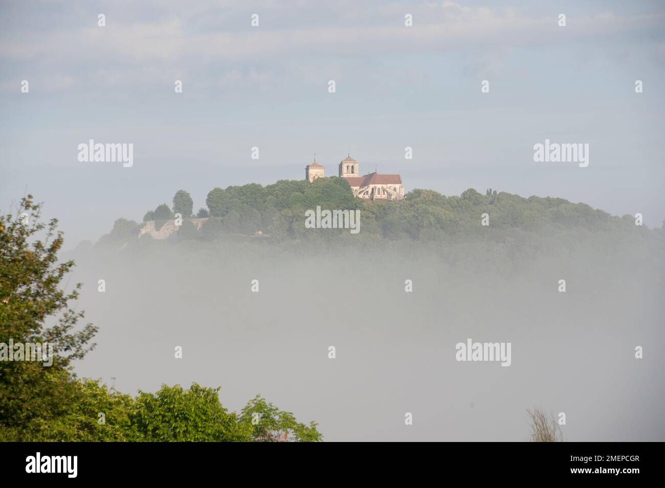 Francia, Borgogna, Yonne, Vezelay, Basilique Sainte-Marie-Madeleine, cattedrale in collina, nebbia sui campi Foto Stock