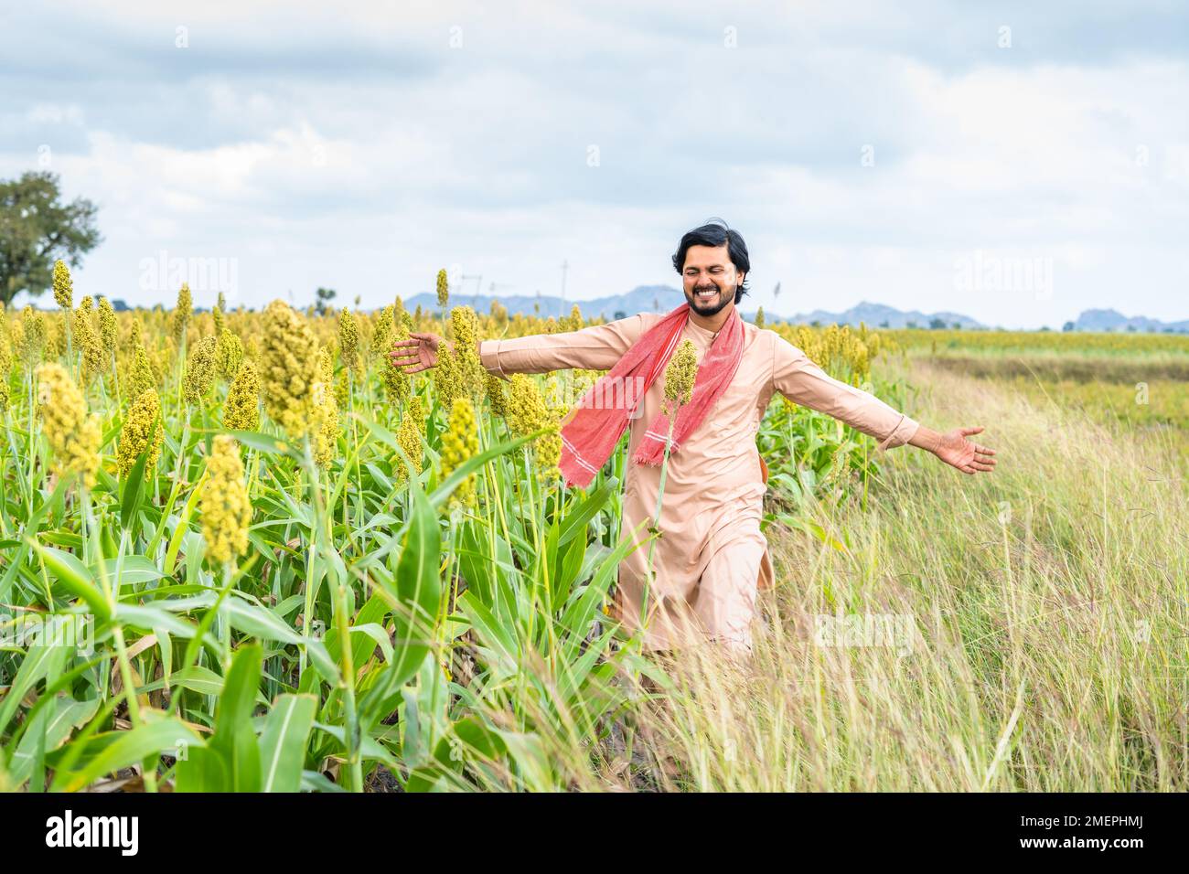 Felice giovane contadino sorridente a piedi al campo di mais da sentire la natura a Framland - concetto di felicità, libertà e spensierato stile di vita villaggio Foto Stock