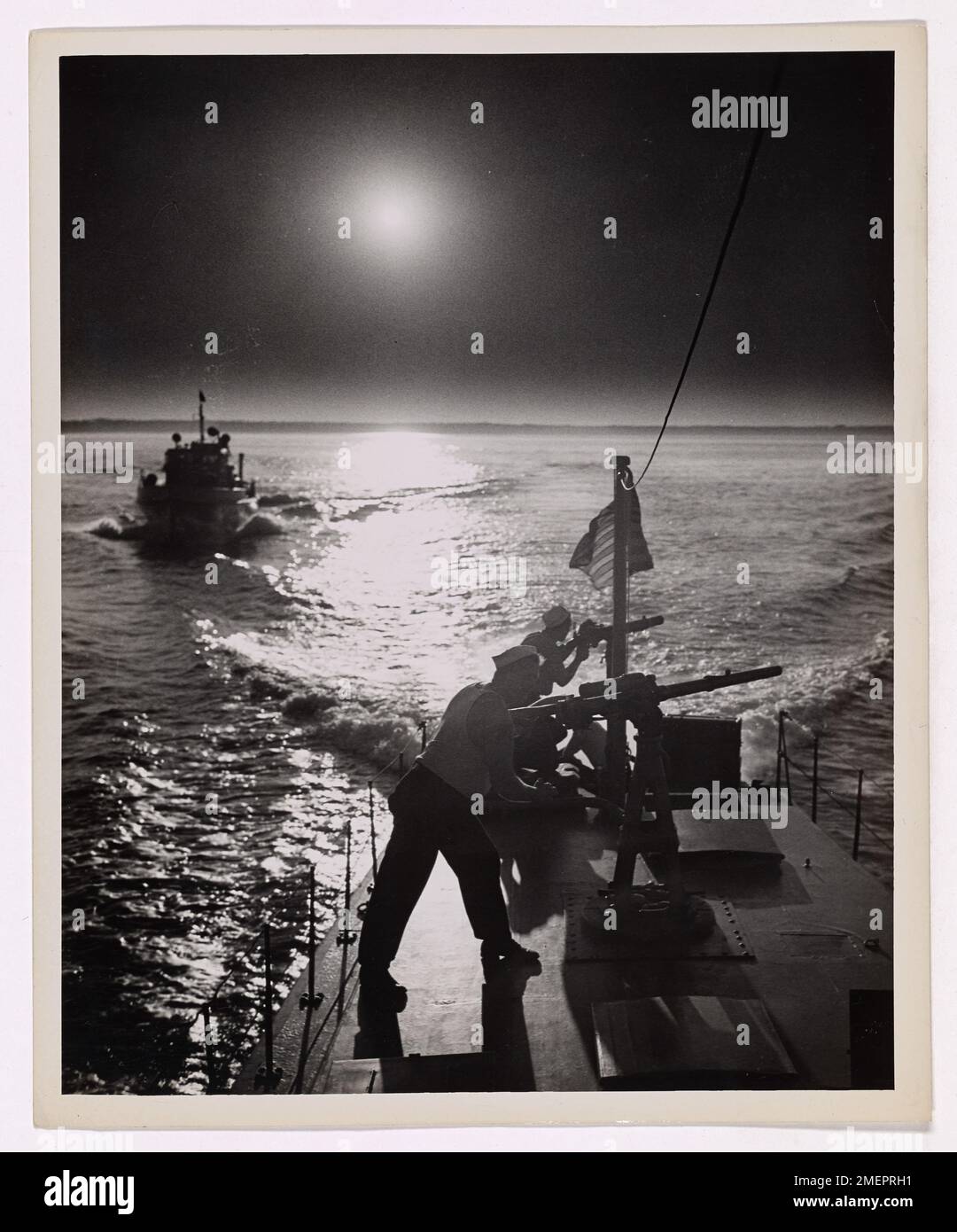 I marinai sono visti maneggiare le loro pistole durante un'operazione notturna. Questa immagine mette in evidenza la vigilanza e la prontezza del personale militare durante le situazioni di combattimento attivo. Foto Stock