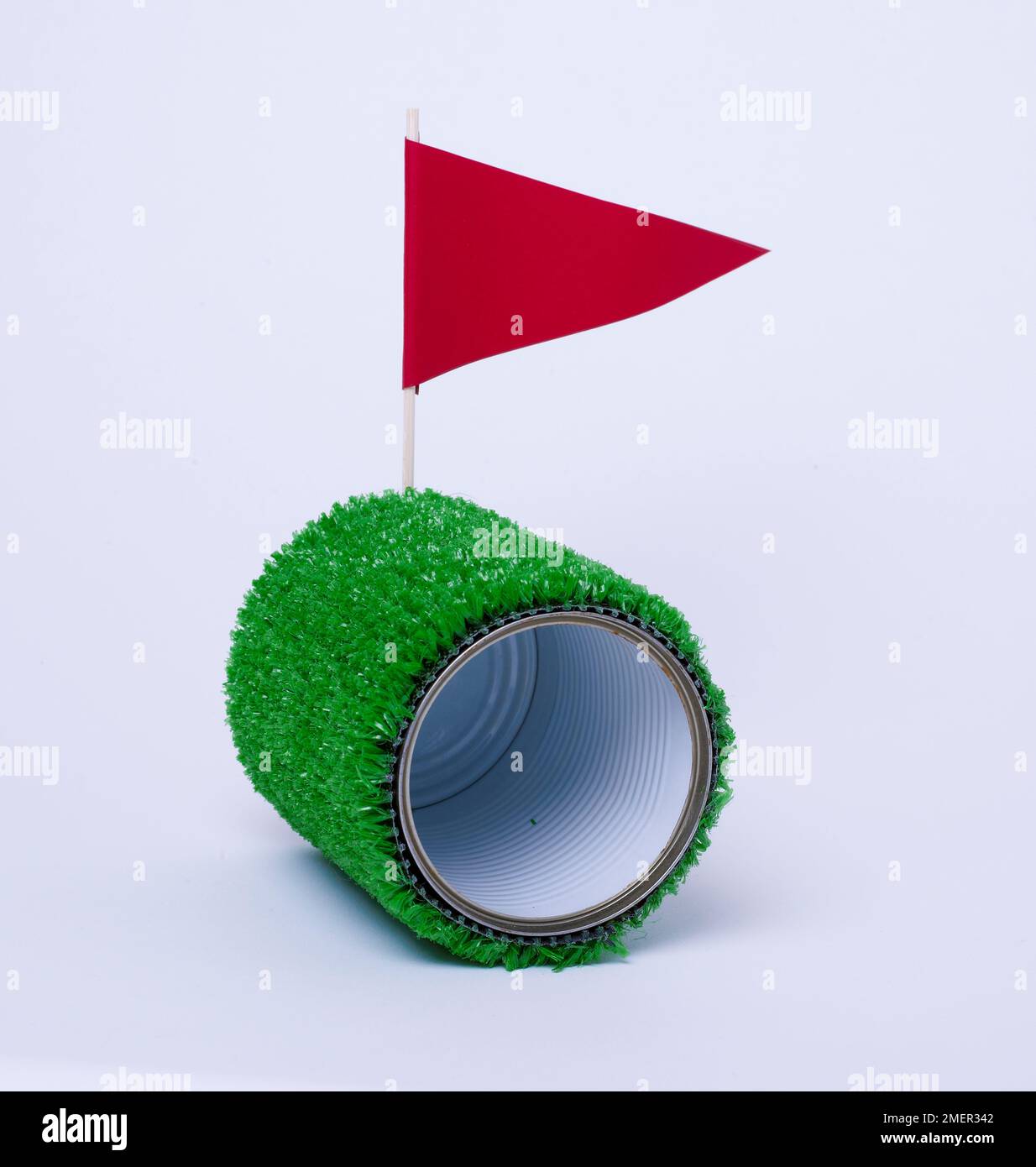 Golf buco, lattina può avvolto in prato astro e bandiera Foto Stock