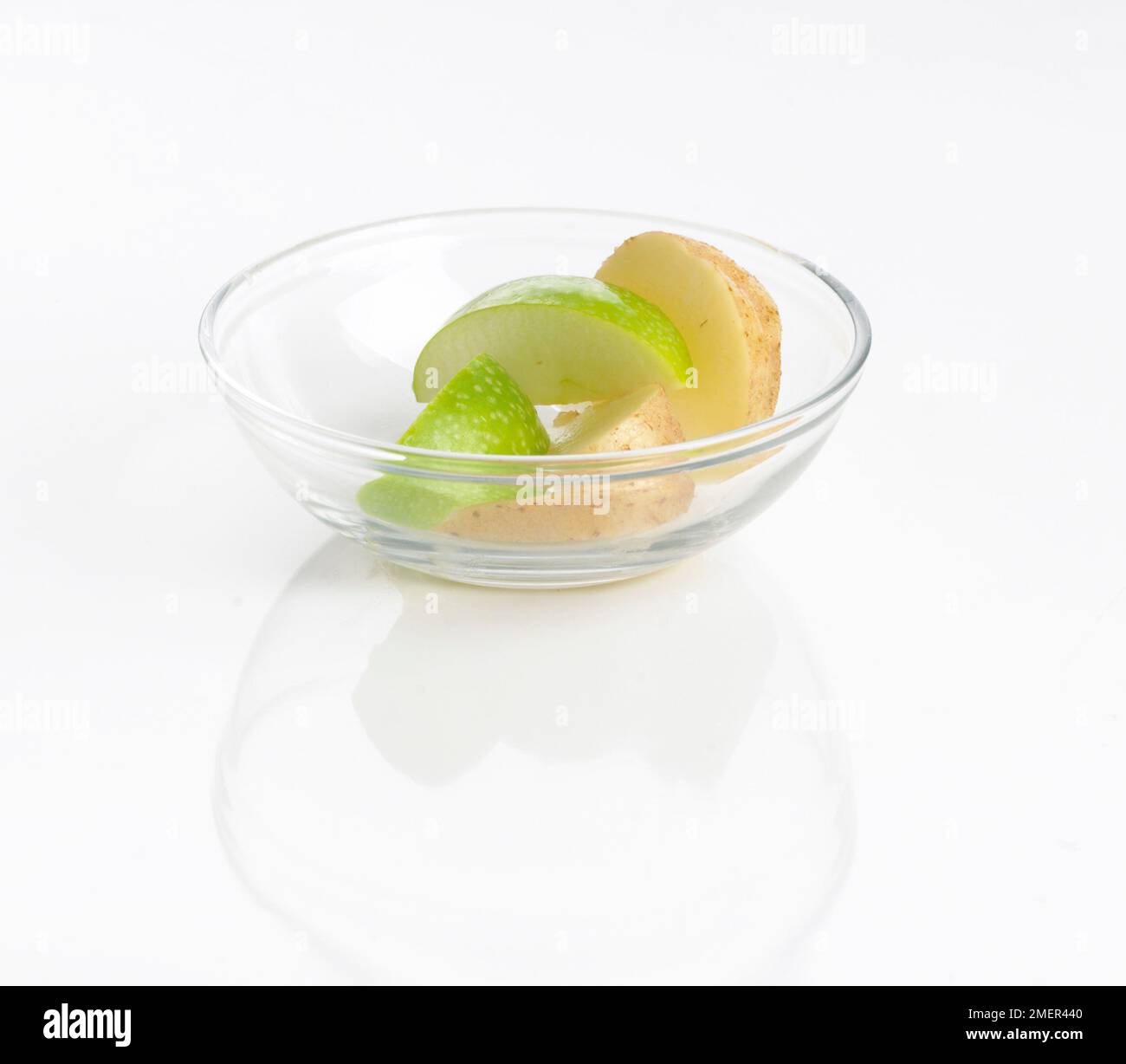 Fette di patate e mela verde in un piccolo recipiente di vetro Foto Stock