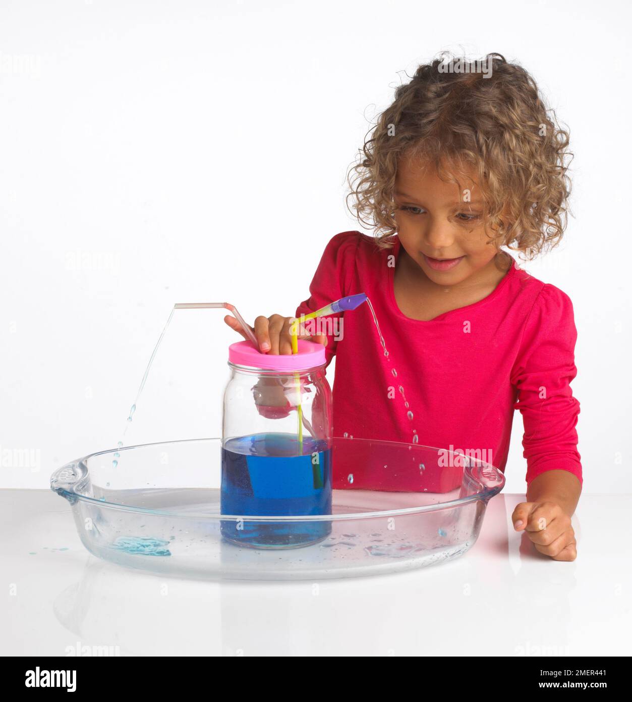 Ragazza che fa l'esperimento di spostamento dell'acqua, 4 anni Foto Stock